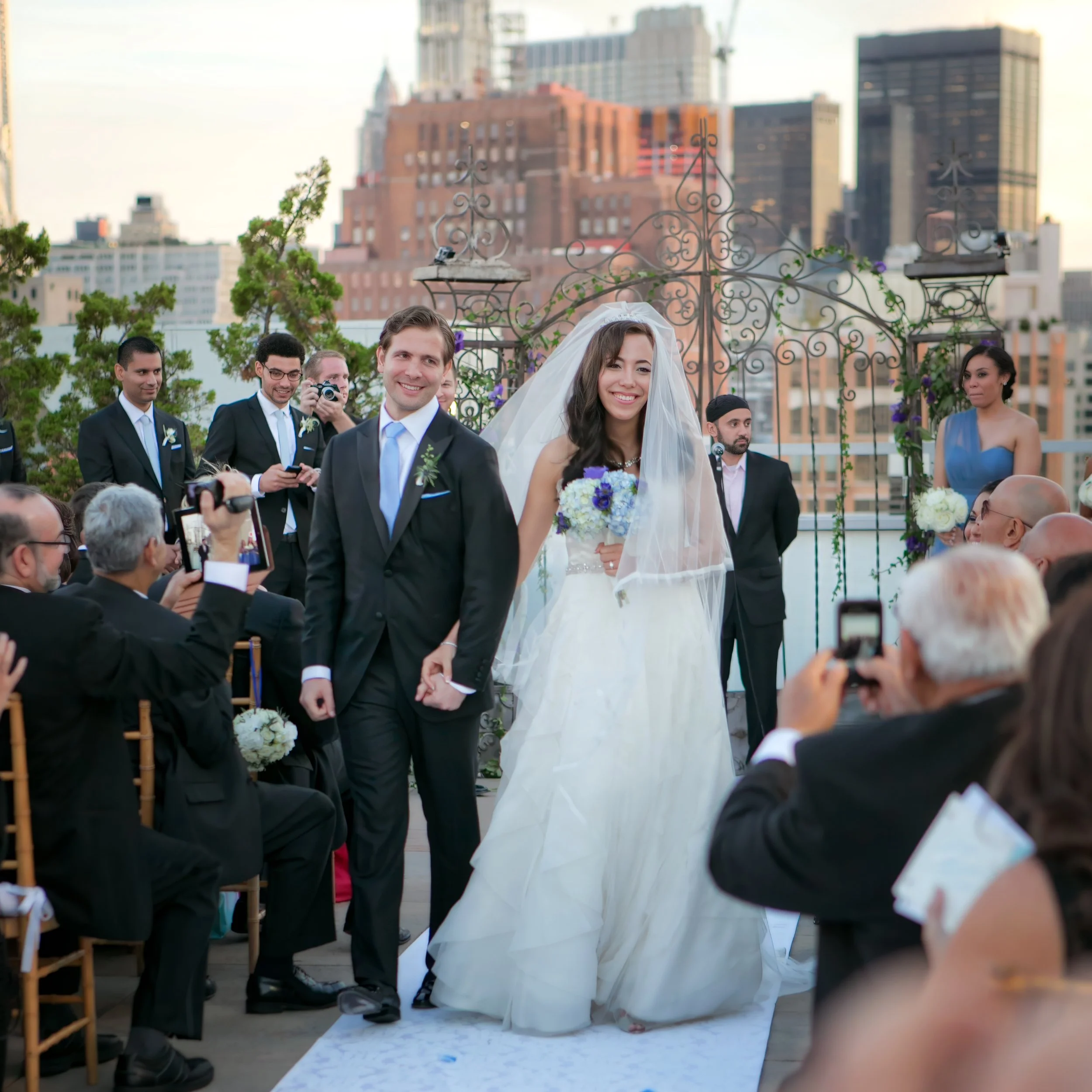 Joyful bride and groom recessional during their wedding ceremony at Tribeca Rooftop in New York City
