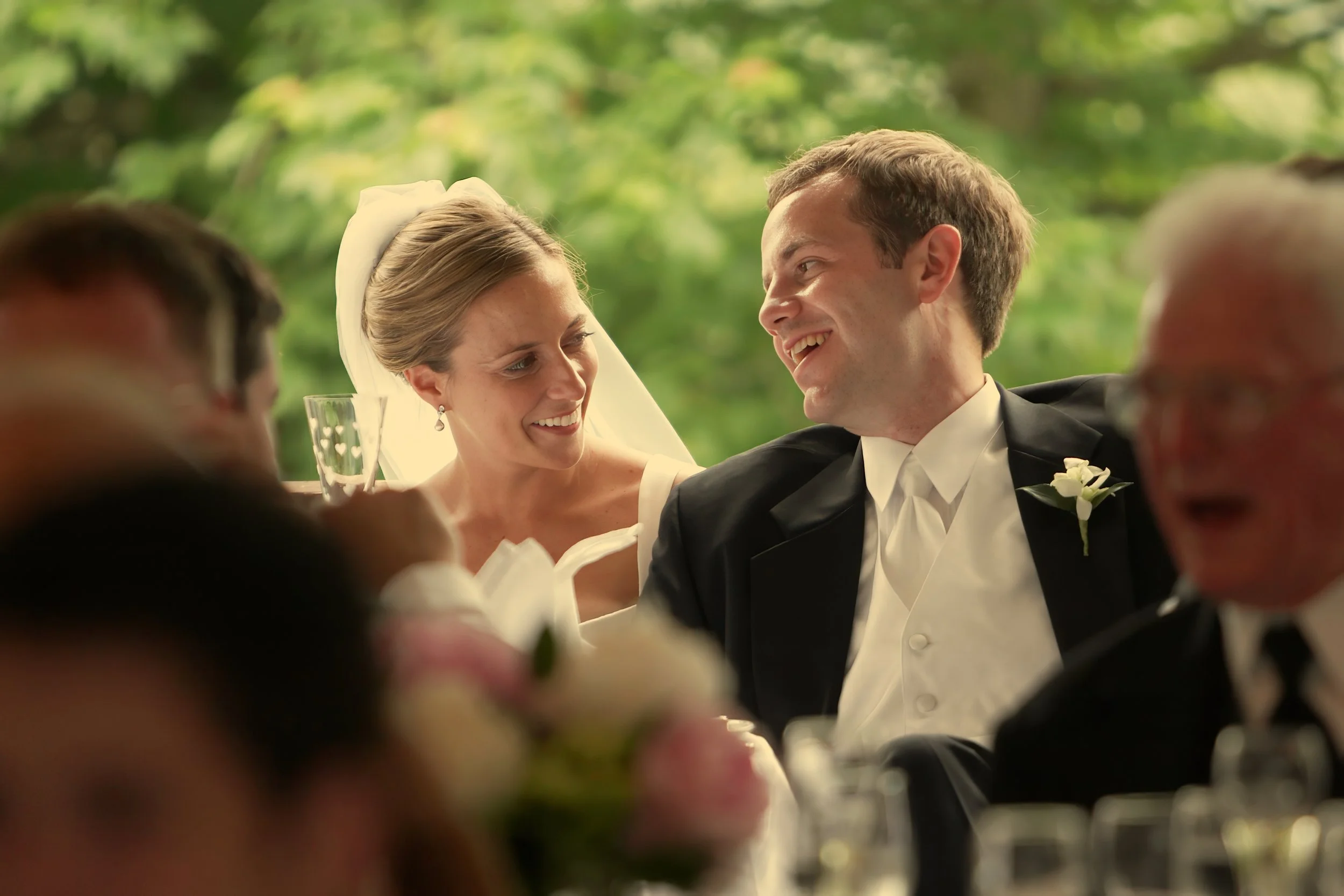 Bride and groom sharing romantic moment during dinner under tent at Inn at Mystic wedding reception