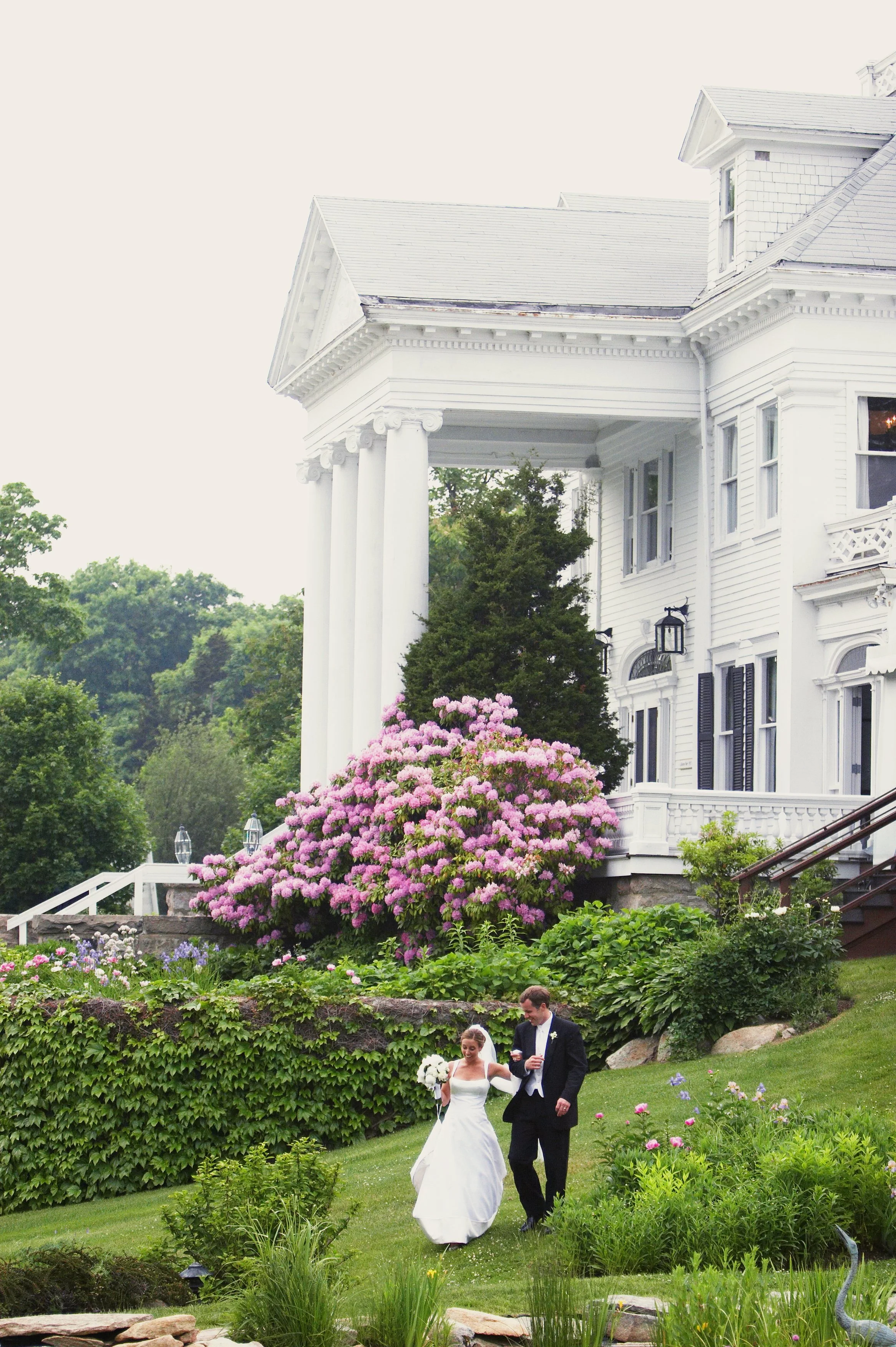 Bride and groom walking the grounds of the Inn at Mystic in natural midday light during a Connecticut wedding