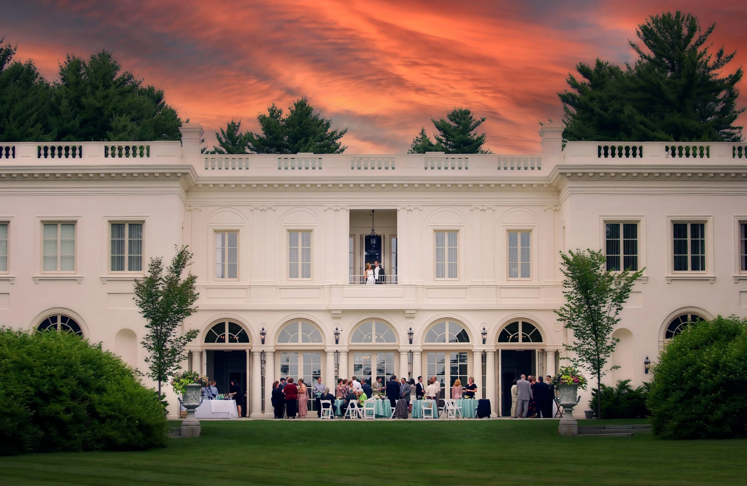 Bride and groom look over terrace at cocktail hour below at Wadsworth Mansion wedding reception