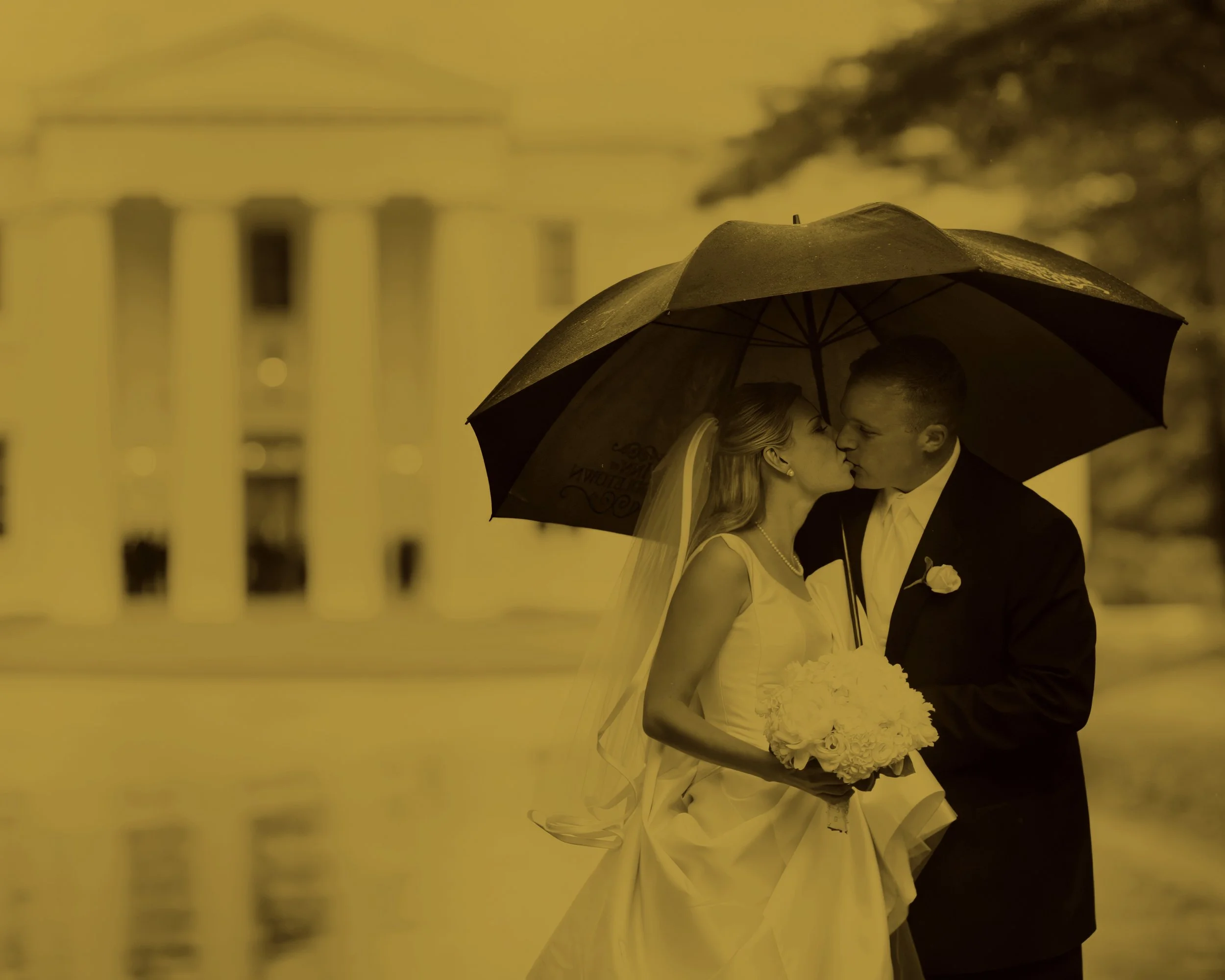 Bride and groom romantic kiss in the rain in front of Wadsworth Mansion exterior