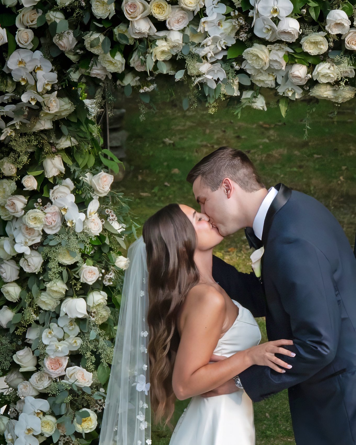 Bride and groom first kiss during side garden wedding ceremony at Lord Thompson Manor Caption: