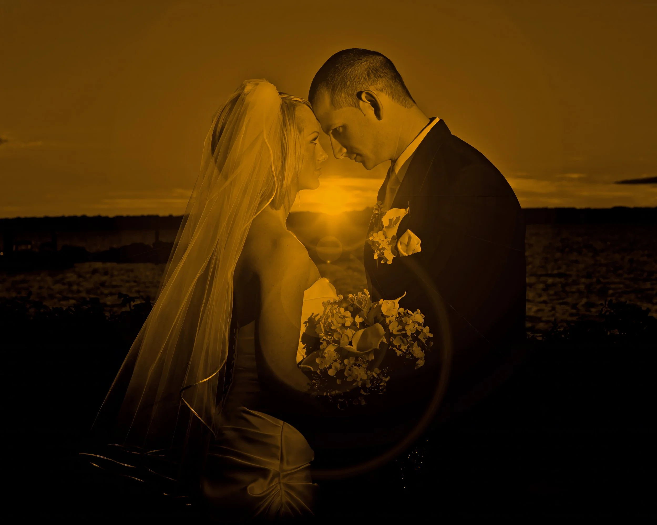 Bride and groom embrace in a romantic sunset portrait overlooking New Haven Harbor at Amarante’s wedding venue