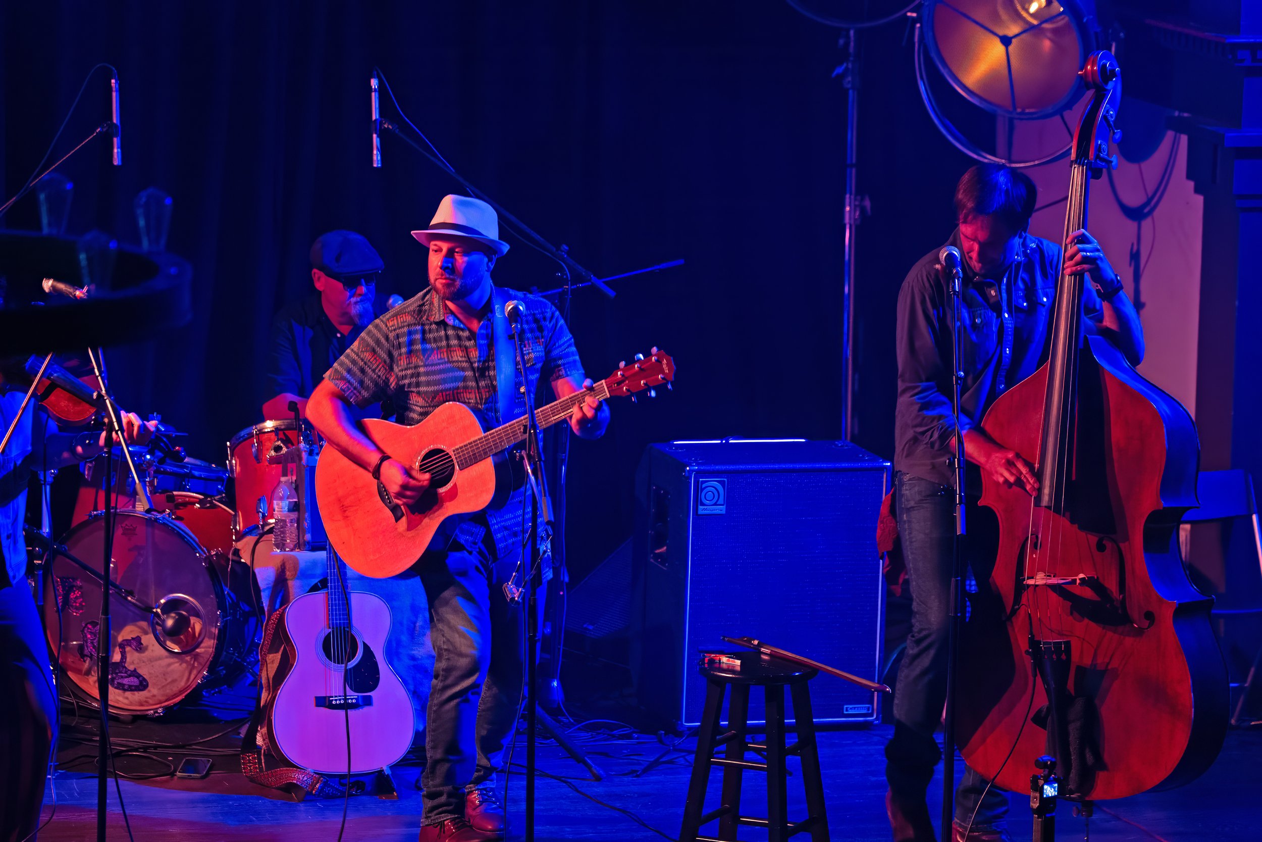 Matt Eckstine on guitar, Zach Smith on upright bass, and Stan Ray on drums performing with The Accomplices under concert lighting at Victory North in Savannah, Georgia.