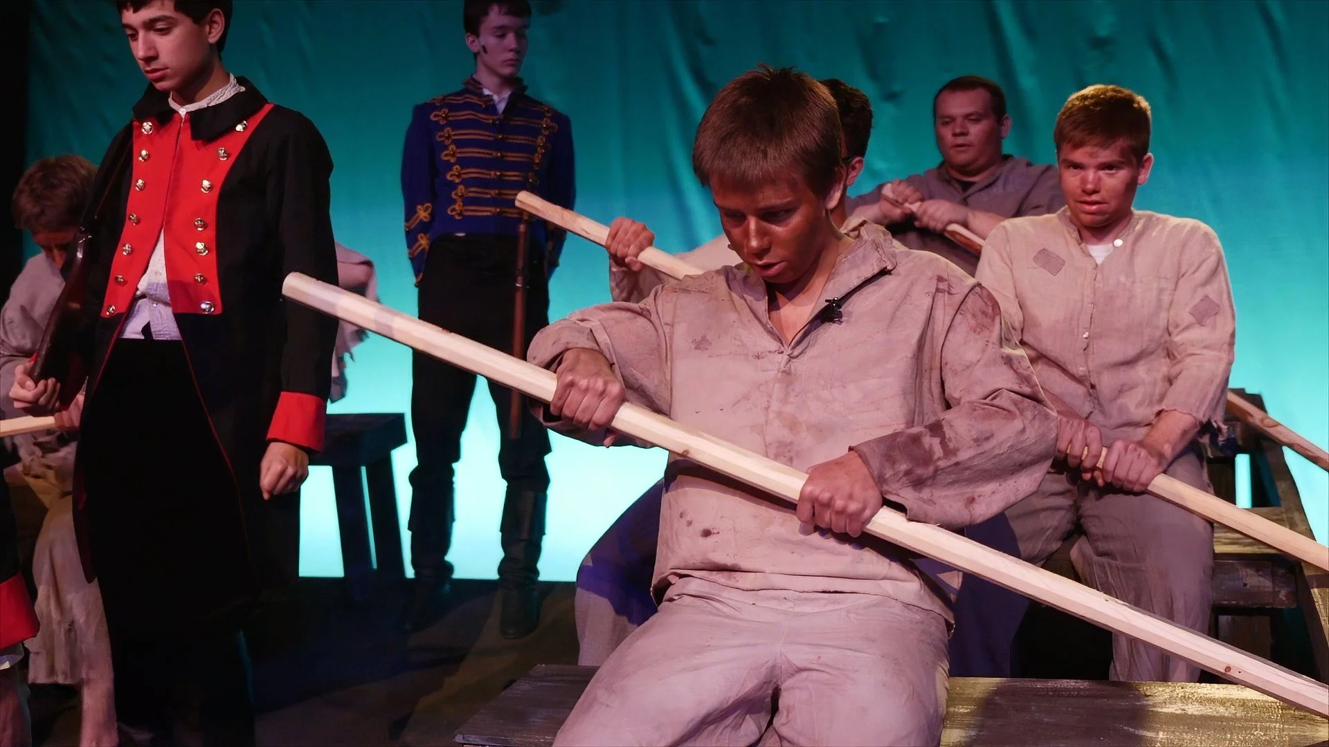 Student performers act out a dramatic rowing scene during Maloney High School's theatrical production of Les Misérables.