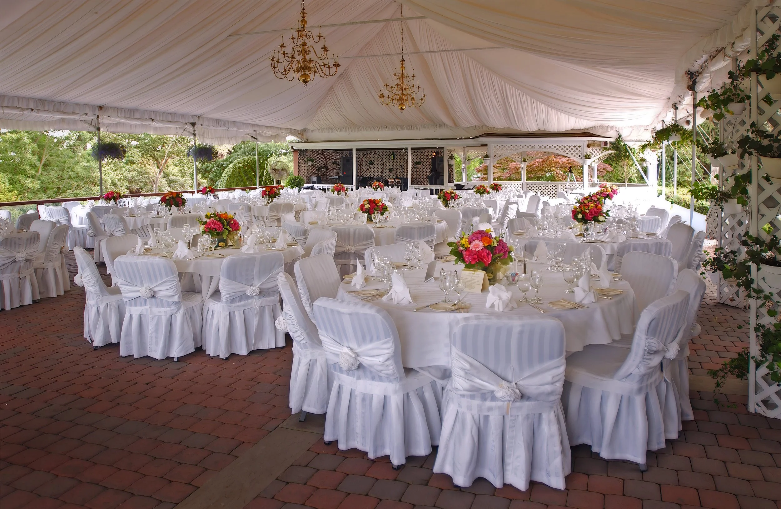 Colorful floral centerpieces decorate tables under the tented wedding reception at the Inn at Mystic.