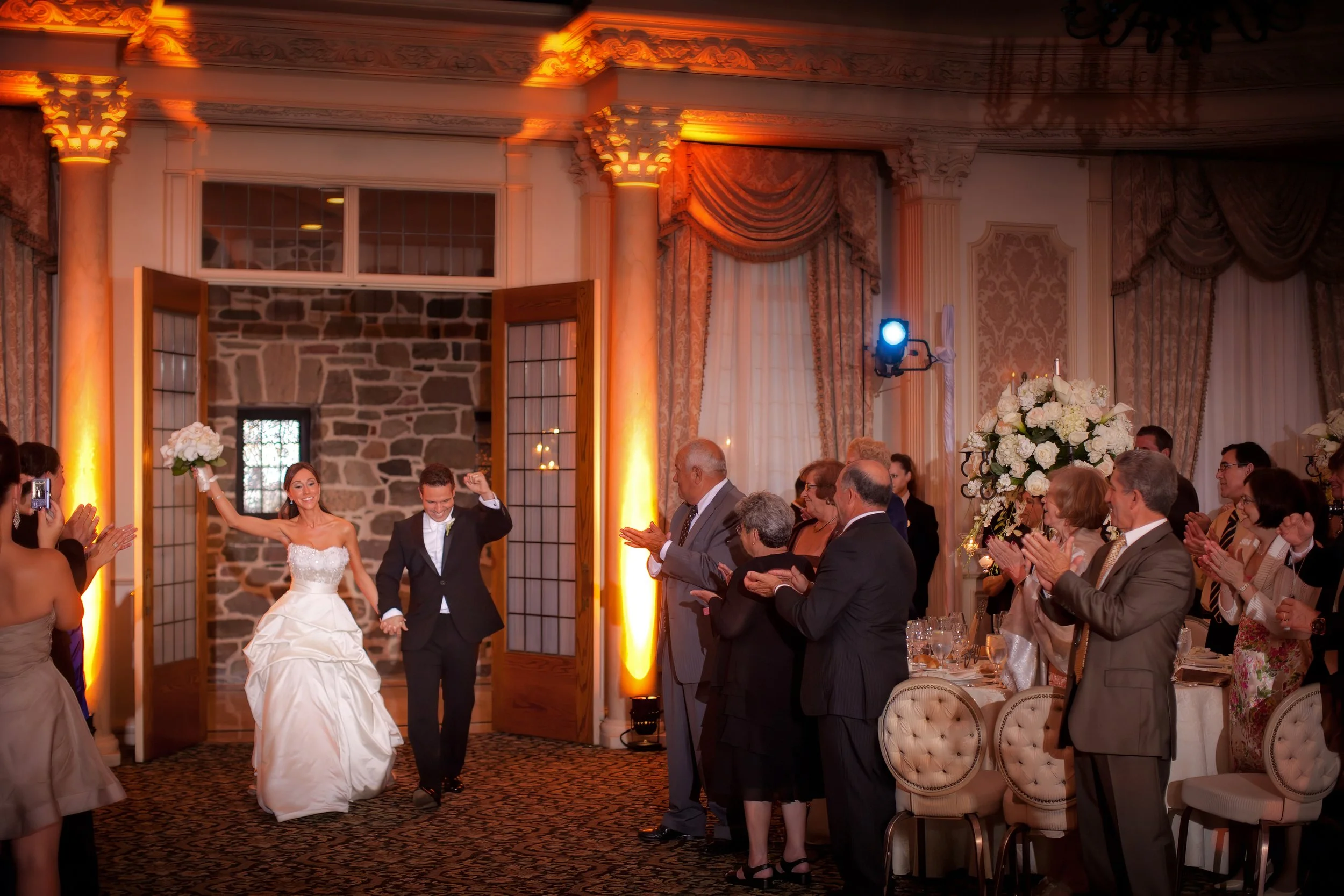Bride and groom joyfully enter their reception as they are announced into the Pleasantdale Chateau ballroom.