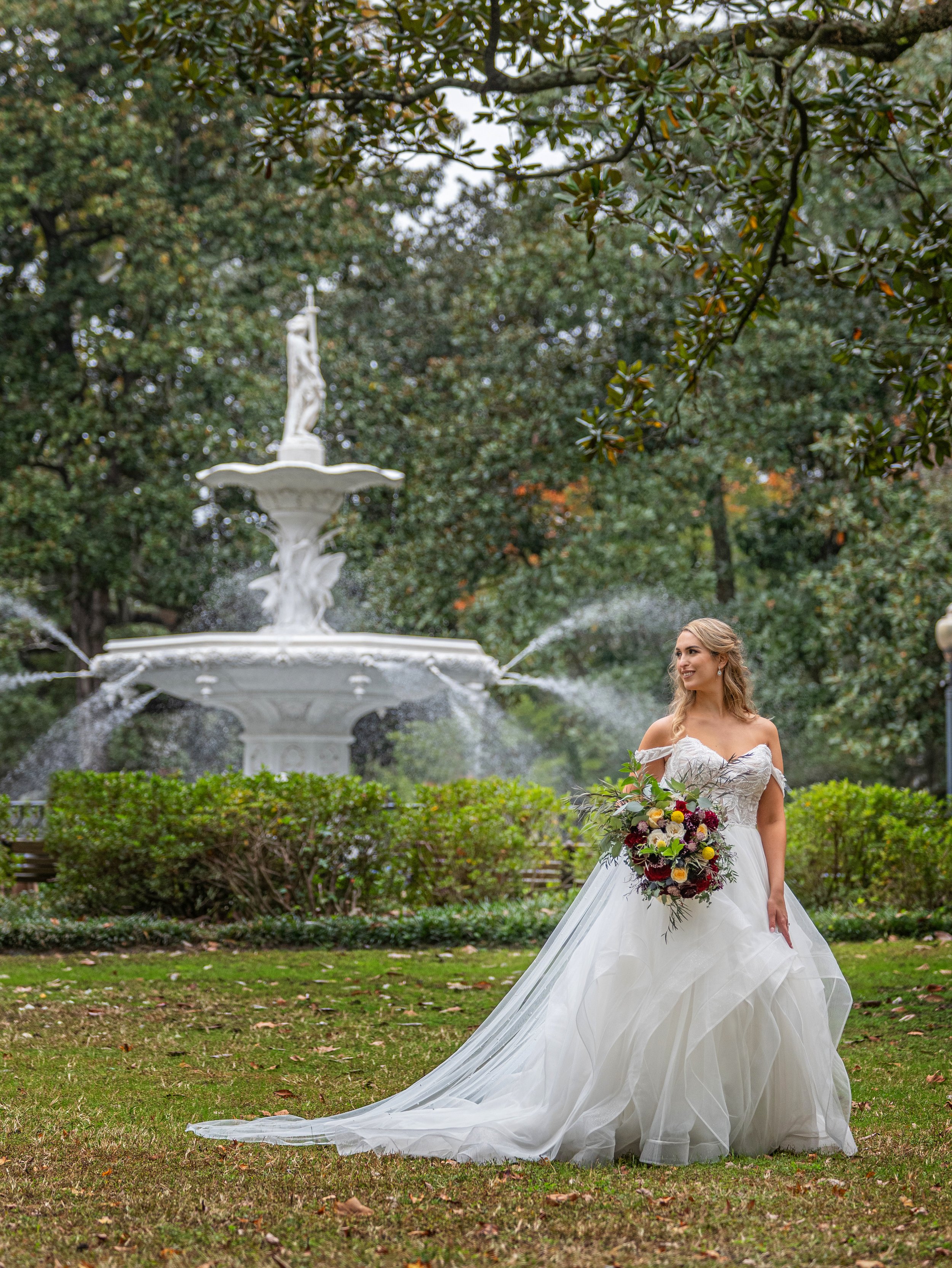Luxurious bridal portrait of a bride at Forsyth Park Fountain, Savannah, emphasizing natural light and elegance.