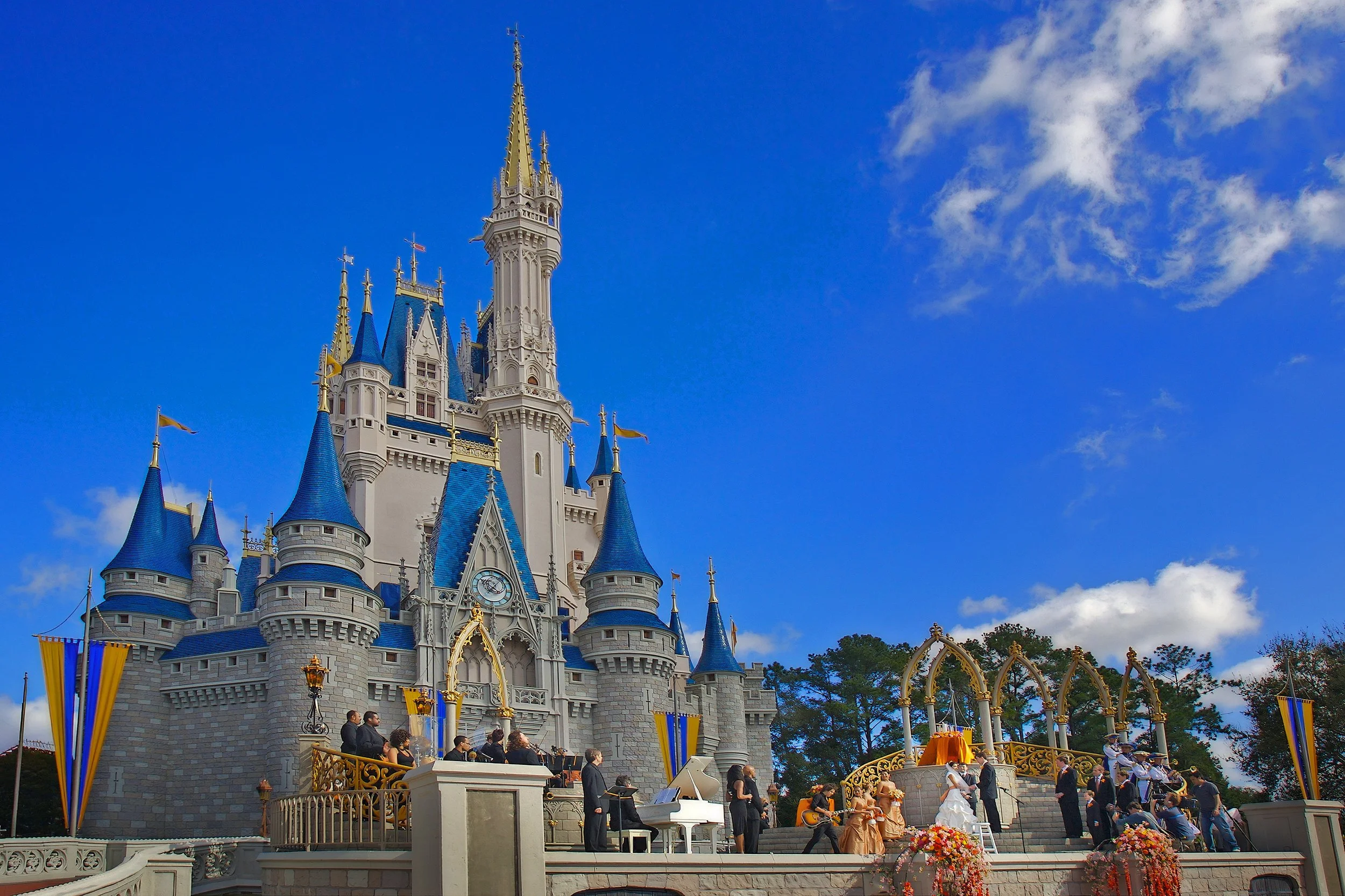 Sweeping view of a wedding ceremony on the steps of Cinderella Castle at Walt Disney World.