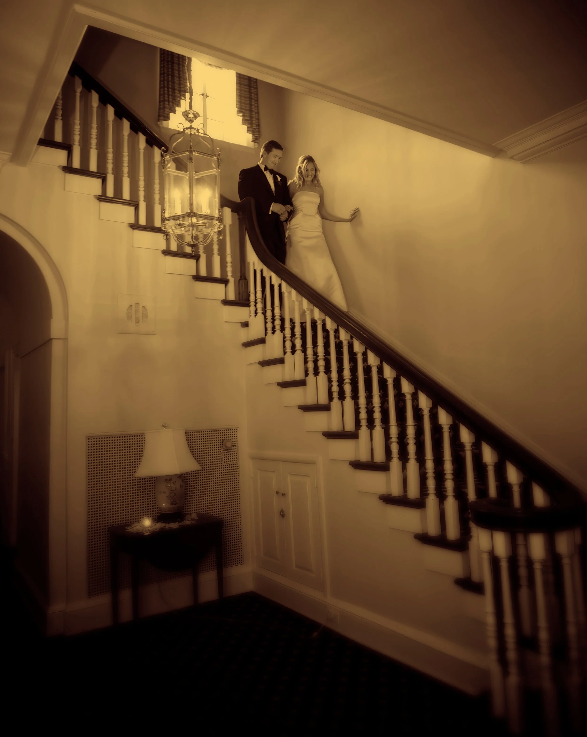 Bride and groom walk down the grand staircase inside Siwanoy Country Club.