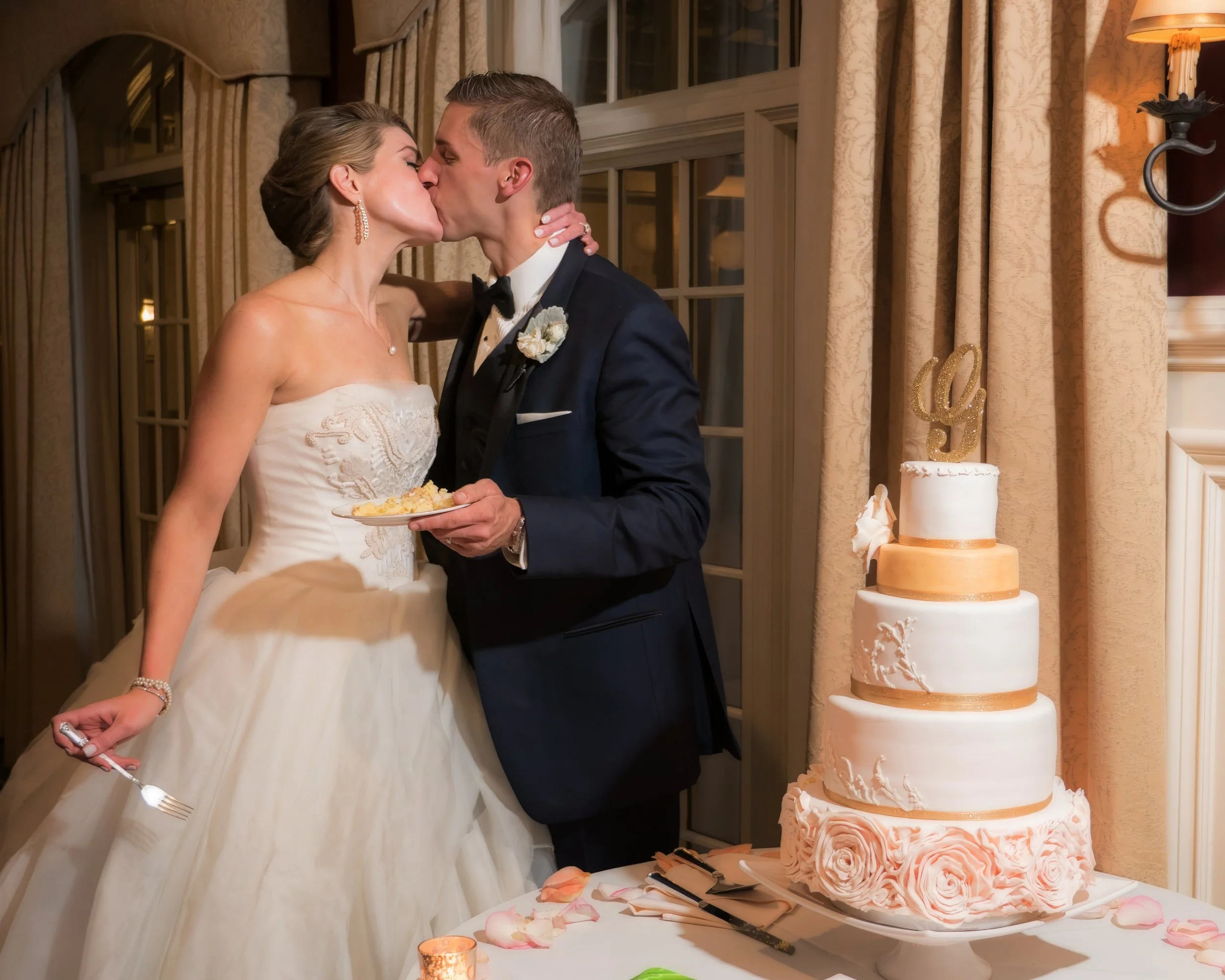 Bride and groom share a kiss after cutting the wedding cake at Salem Golf Club.