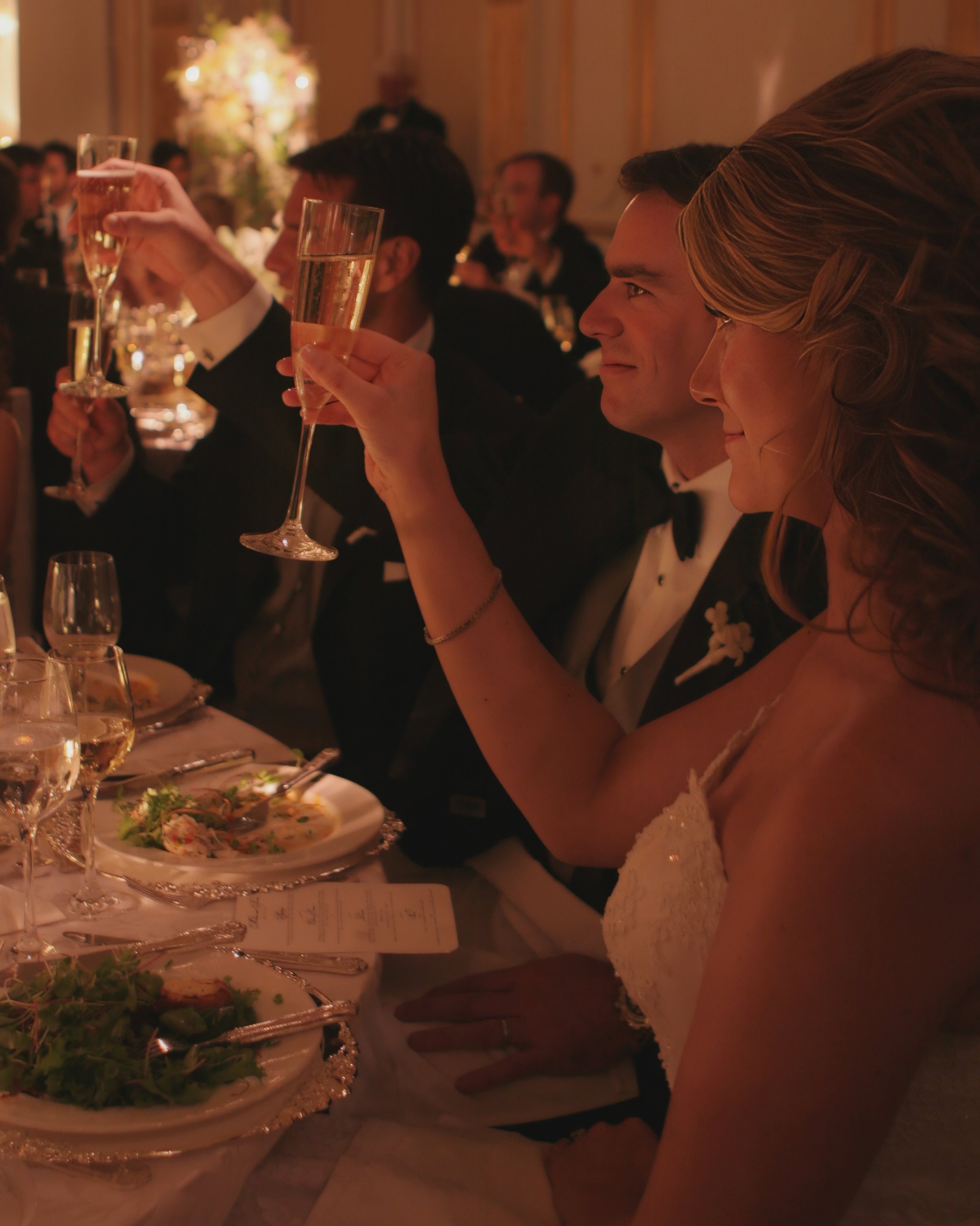 Bride and groom sharing a candlelit toast inside the ballroom at the Lotte New York Palace Hotel.
