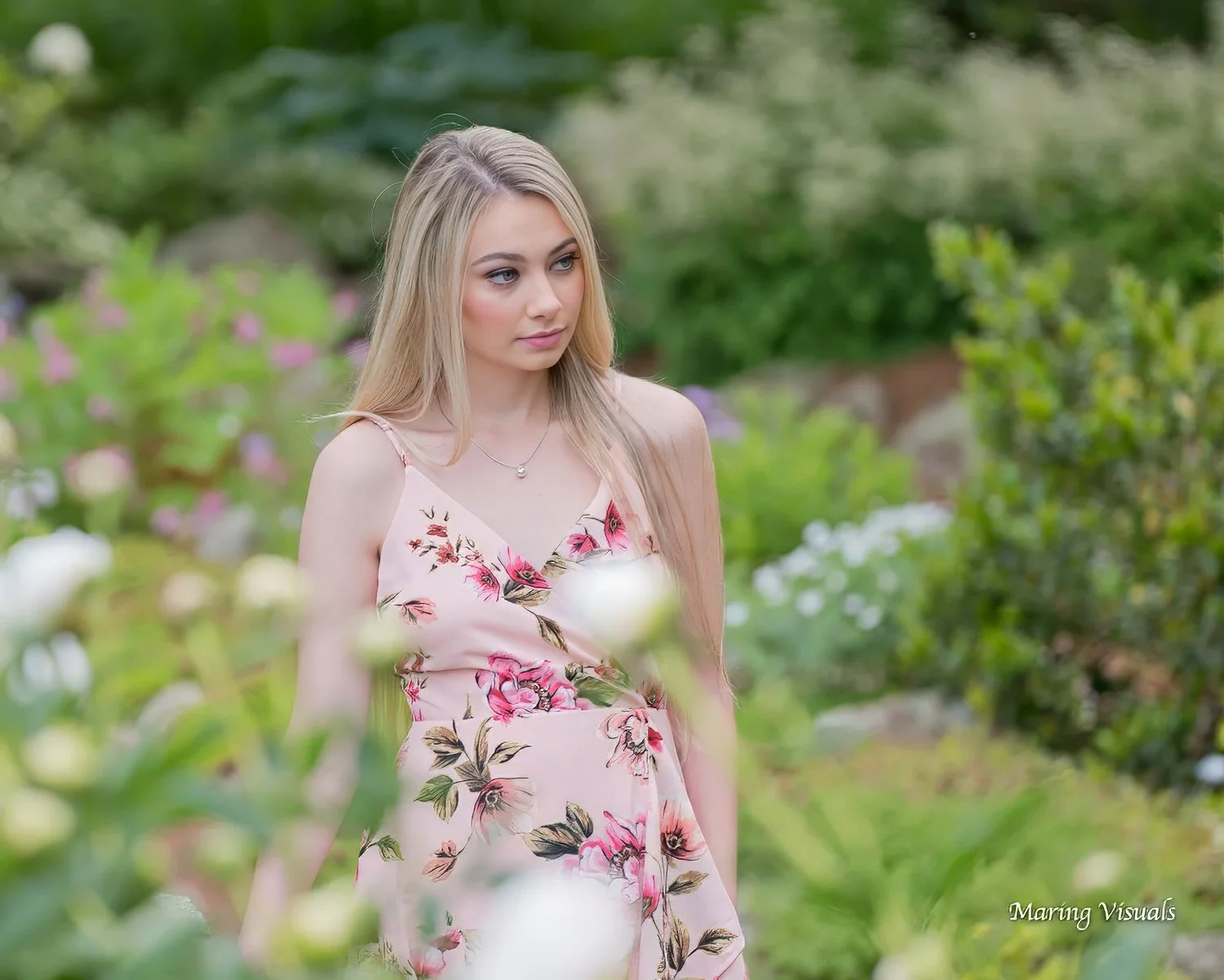 Senior portrait of a young woman walking through the floral gardens of Elizabeth Park in West Hartford, Connecticut.