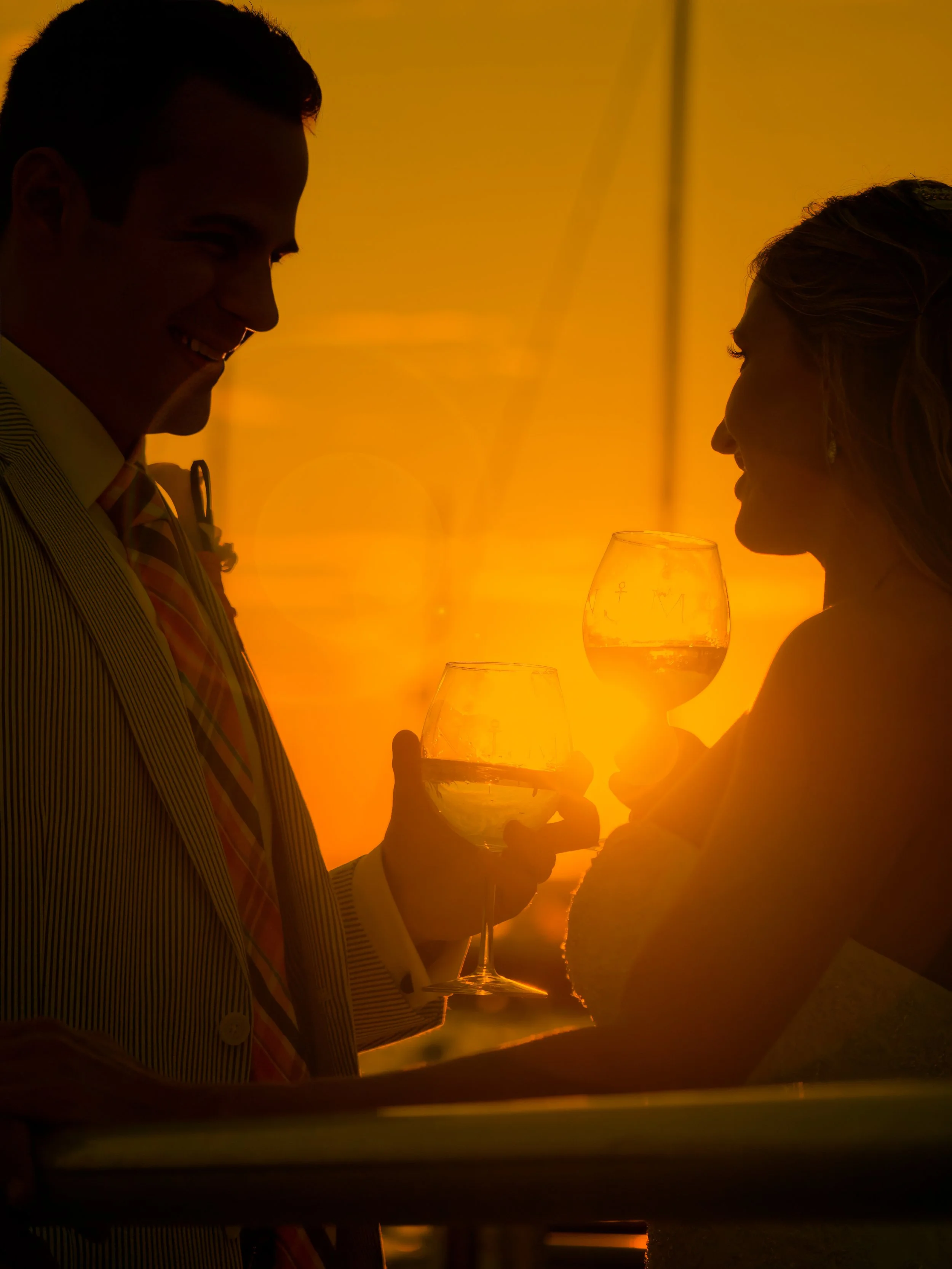 Newlyweds share a romantic sunset toast at Newport Yachting Center during their wedding celebration.