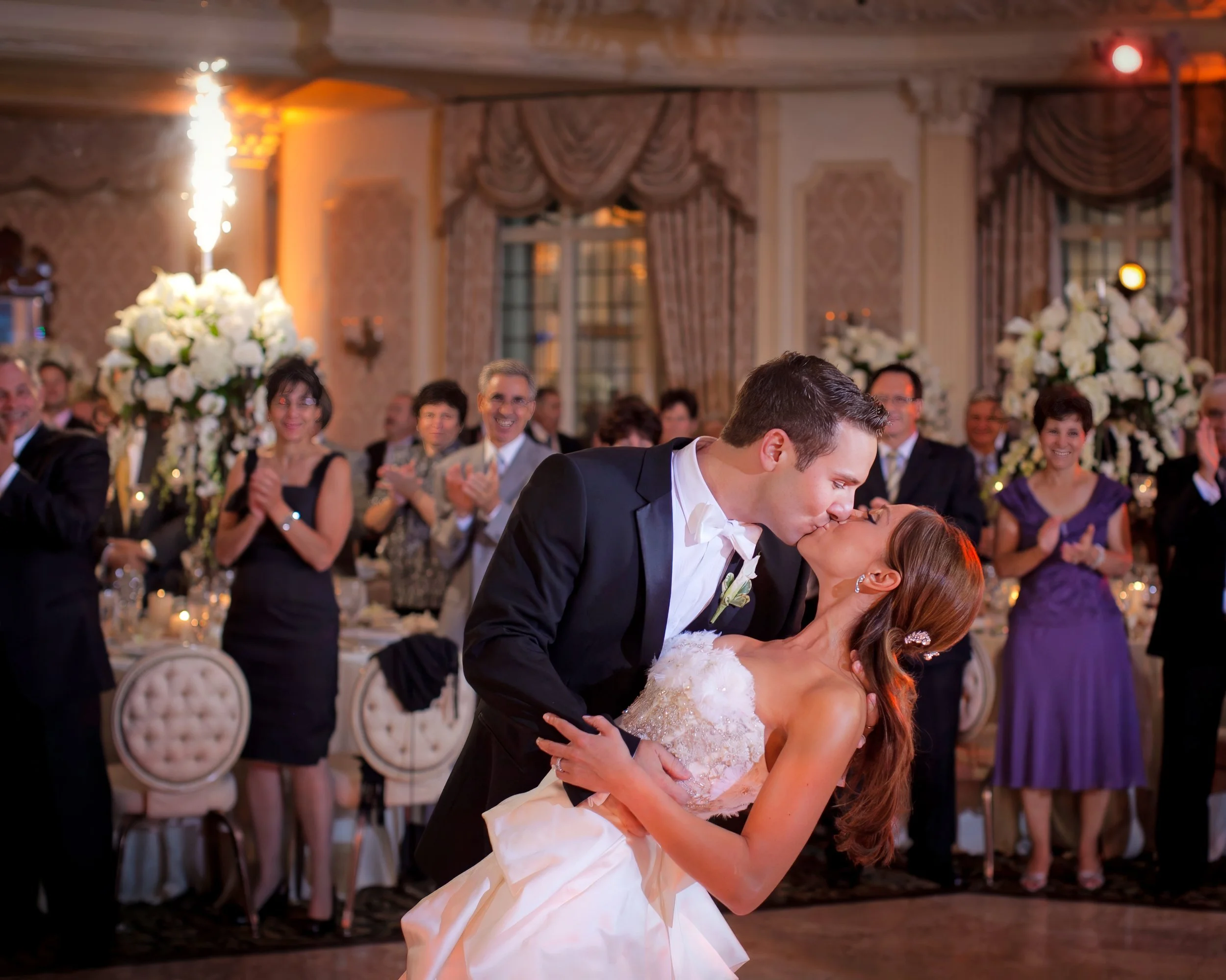Groom dips his bride on the dance floor as fireworks illuminate the ballroom at Pleasantdale Chateau in West Orange, NJ.