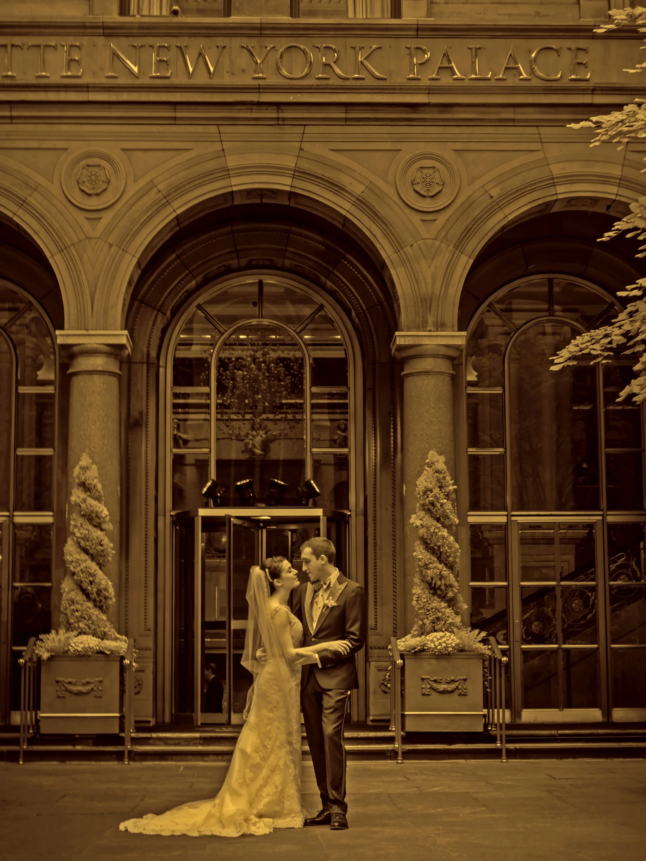 Fine art split tone portrait of a bride and groom embracing in the courtyard of the Lotte New York Palace Hotel.