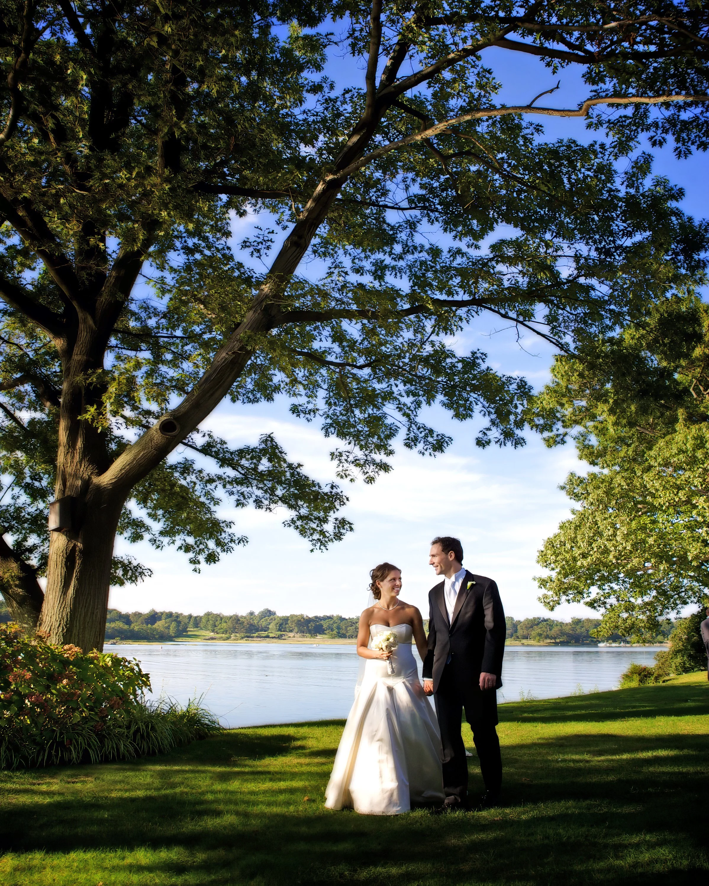 Bride and groom walking along the shoreline of Milton Harbor at Wainwright House in Westchester NY.
