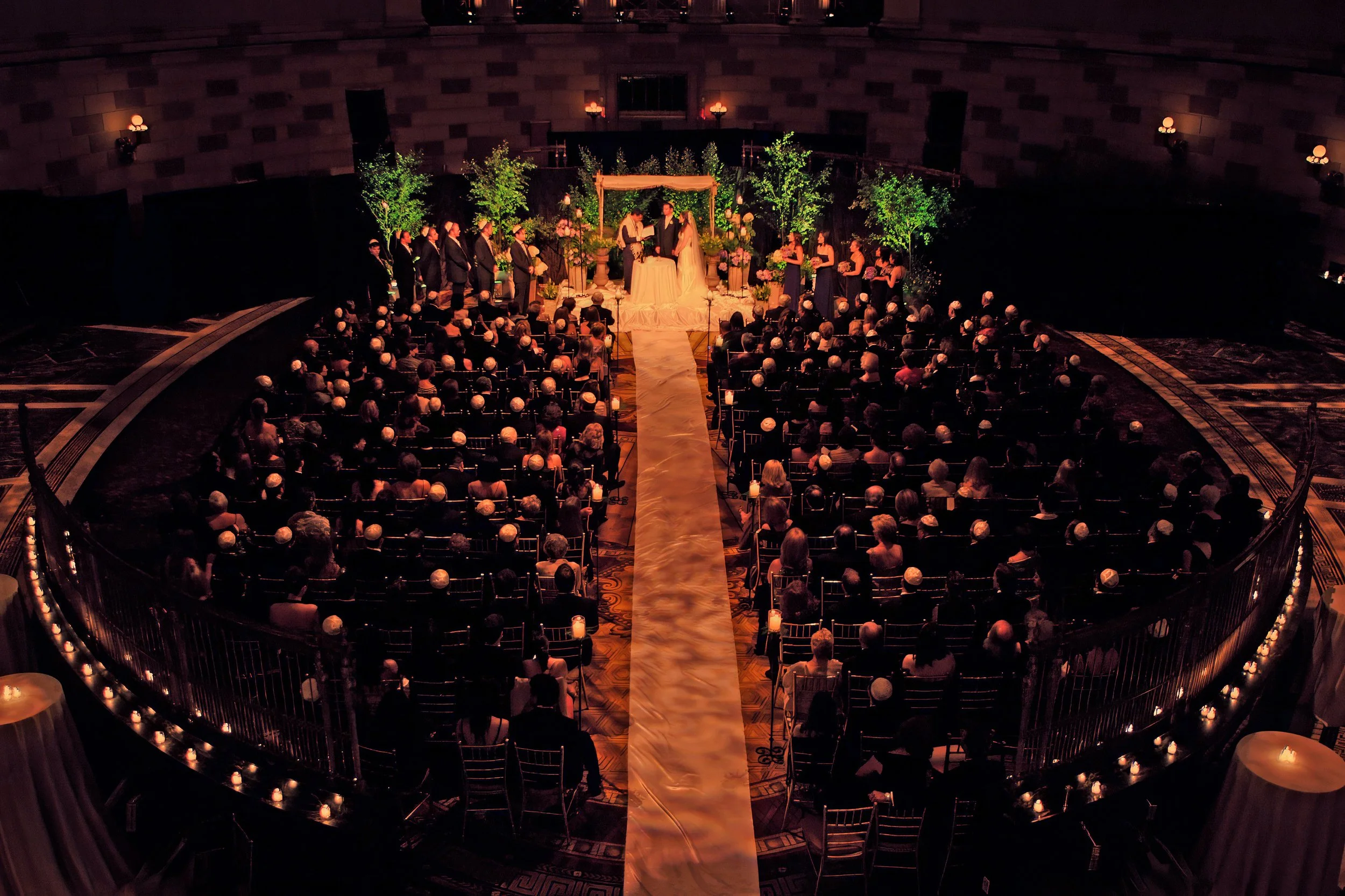 Bride and groom standing beneath the grand dome during a wedding ceremony at Gotham Hall in New York City.