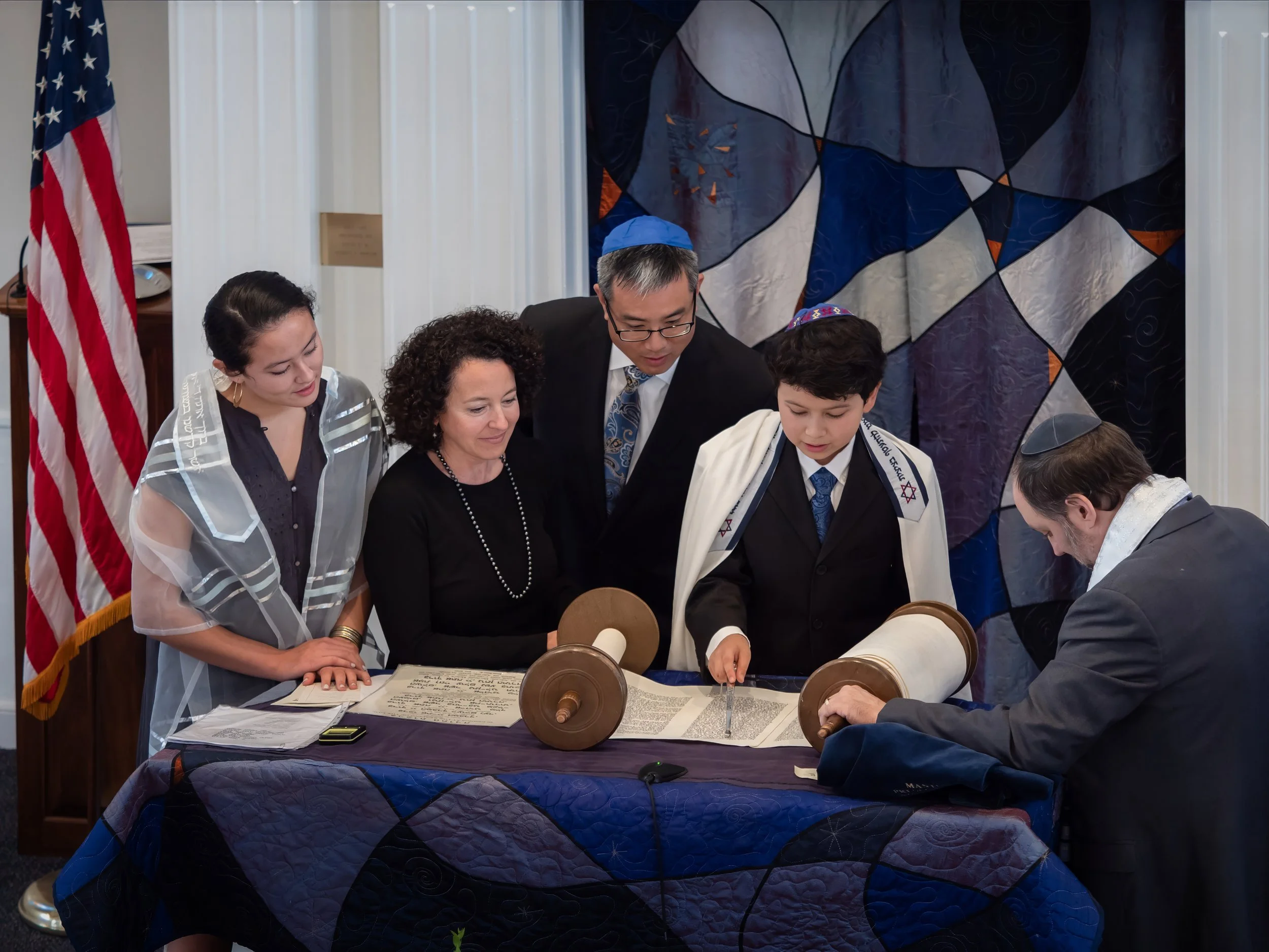 oung man reading the Torah with family during a Bar Mitzvah at Temple Beth David in Cheshire, Connecticut.