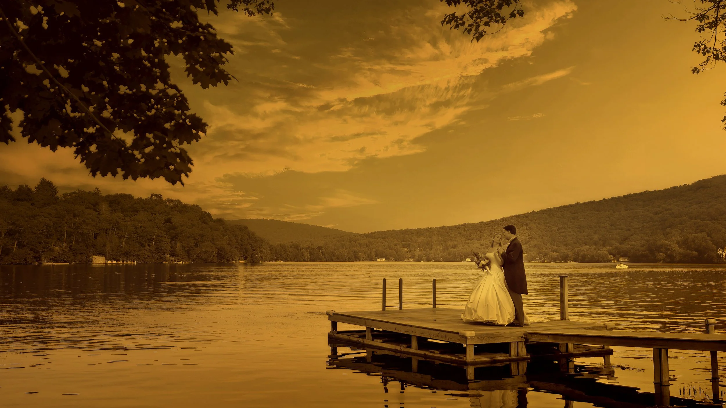 Bride and groom standing on the dock of a family lake house on Lake Waramaug in New Preston Connecticut.
