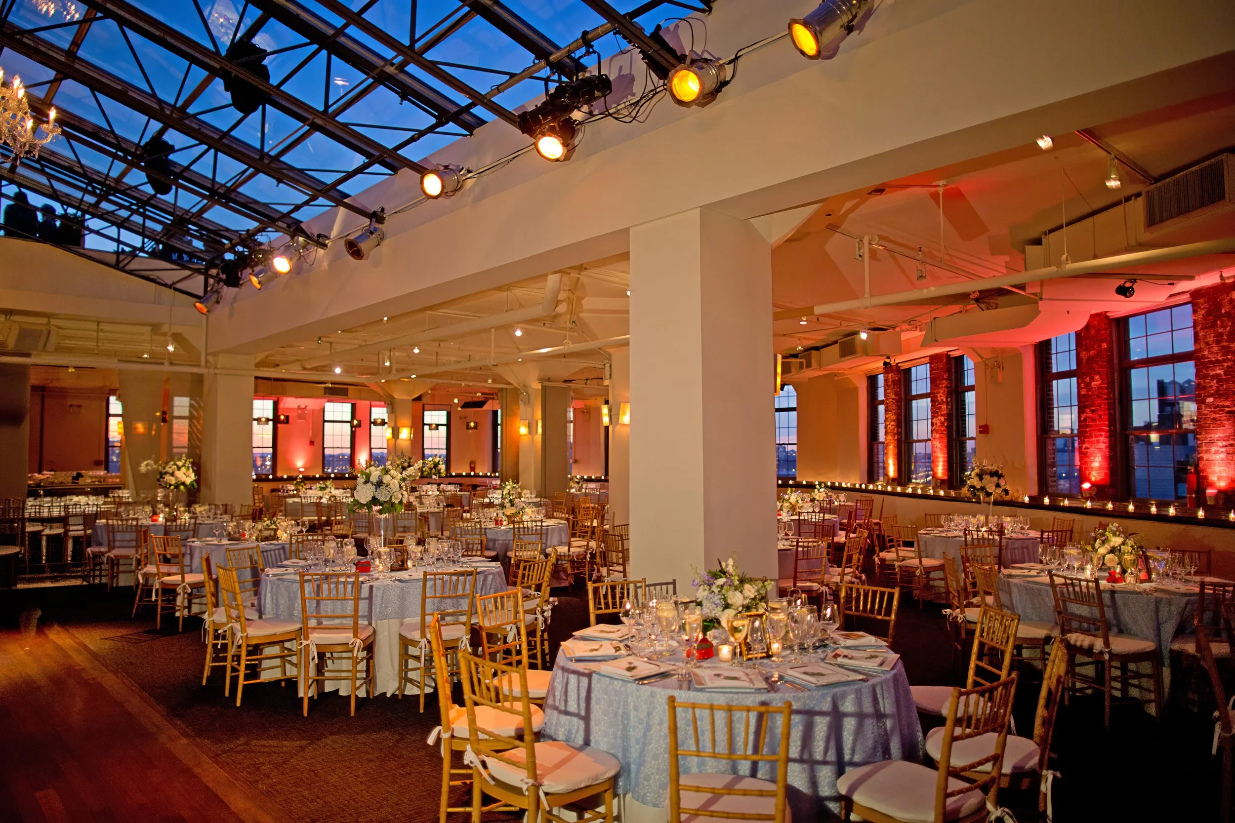 Ballroom decor set beneath the skylight at Tribeca Rooftop in Lower Manhattan, showcasing an elegant wedding reception setup.