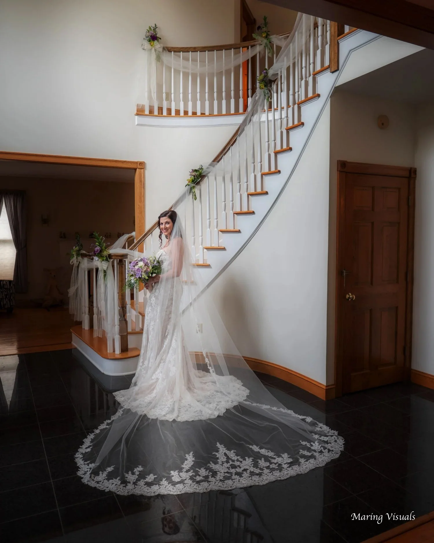 The bride poses for a portrait beneath the staircase of her family home.