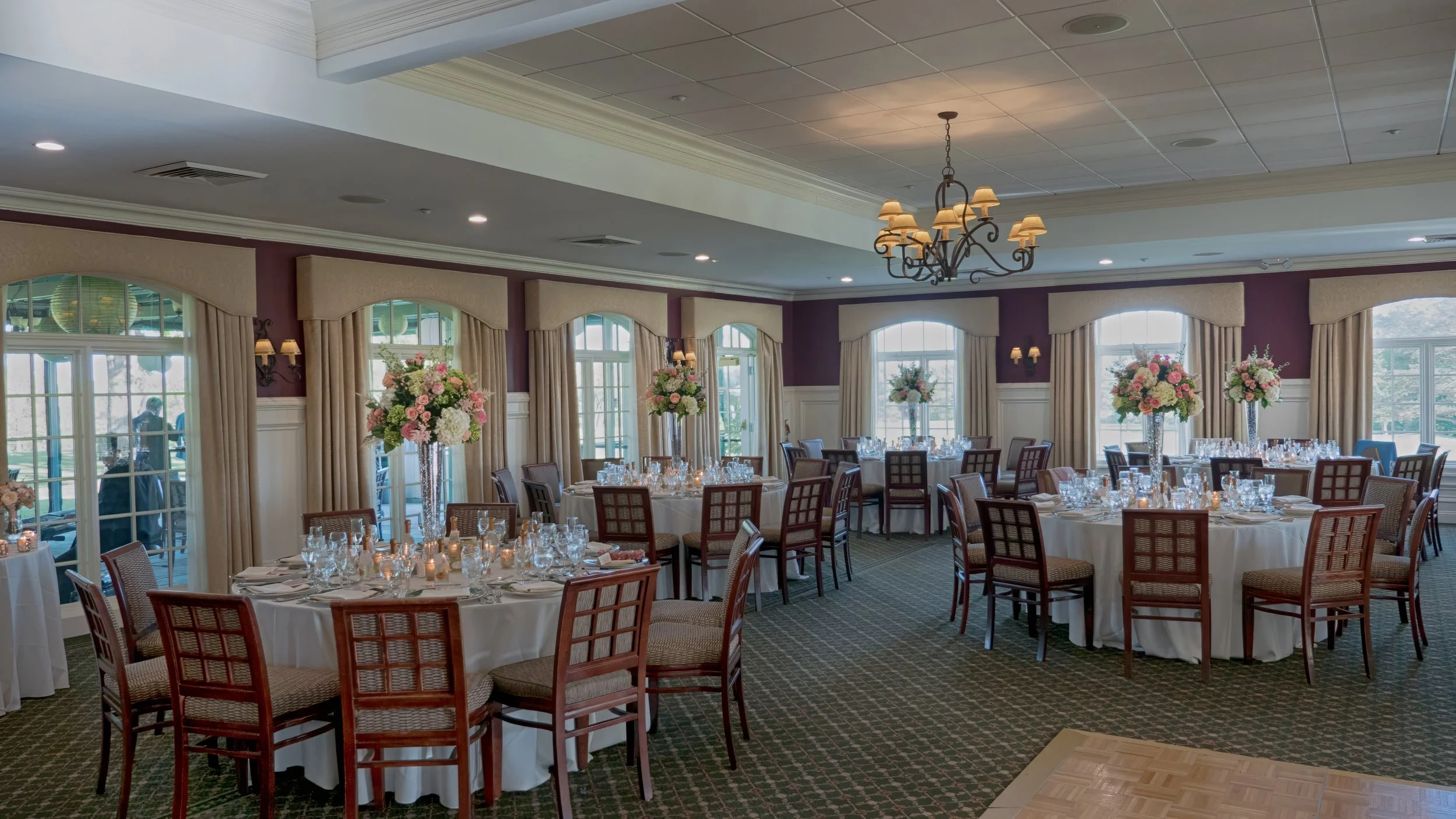 Salem Golf Club clubhouse ballroom decorated with tall floral arrangements for a wedding reception.