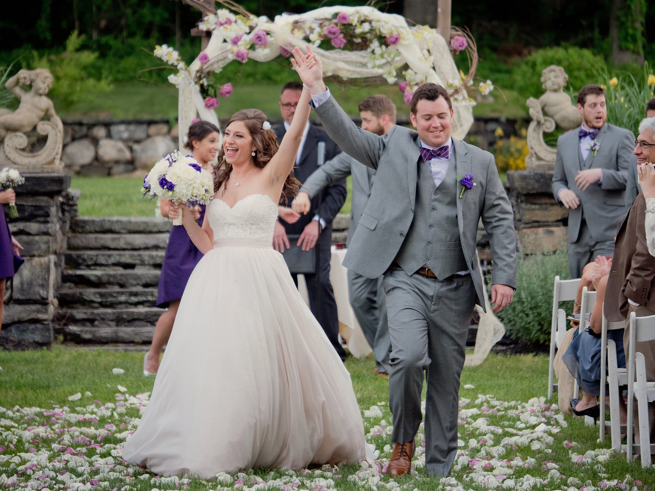 Bride and groom celebrate down the aisle after their wedding ceremony in the sunken gardens at Saint Clements Castle.