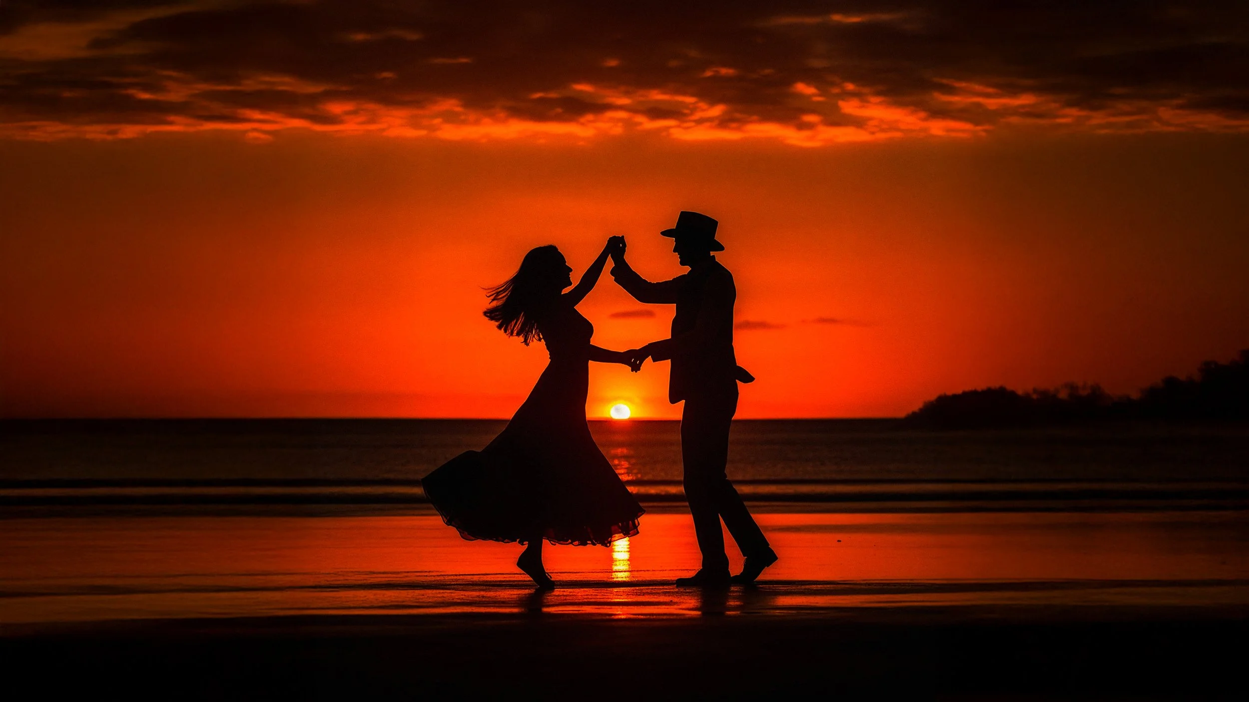An engagement couple dances at sunrise