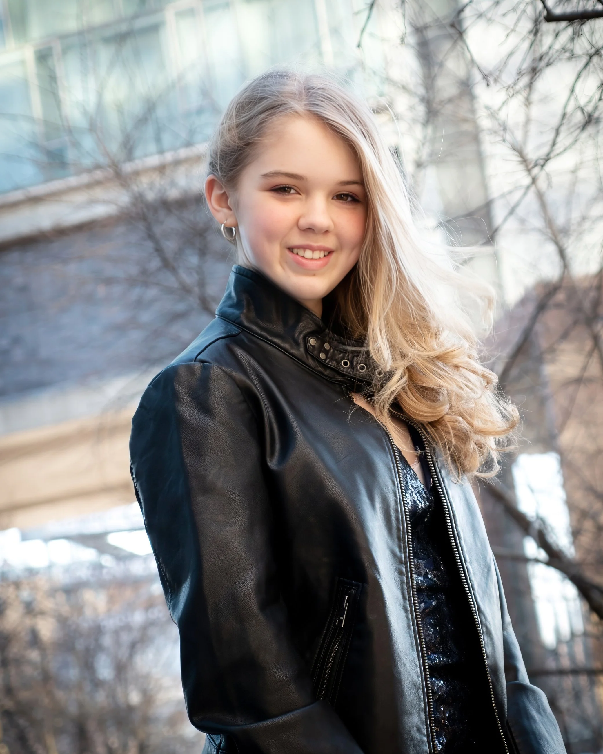 Senior portrait headshot of a young woman on The High Line in Manhattan with the Standard Hotel in the background.