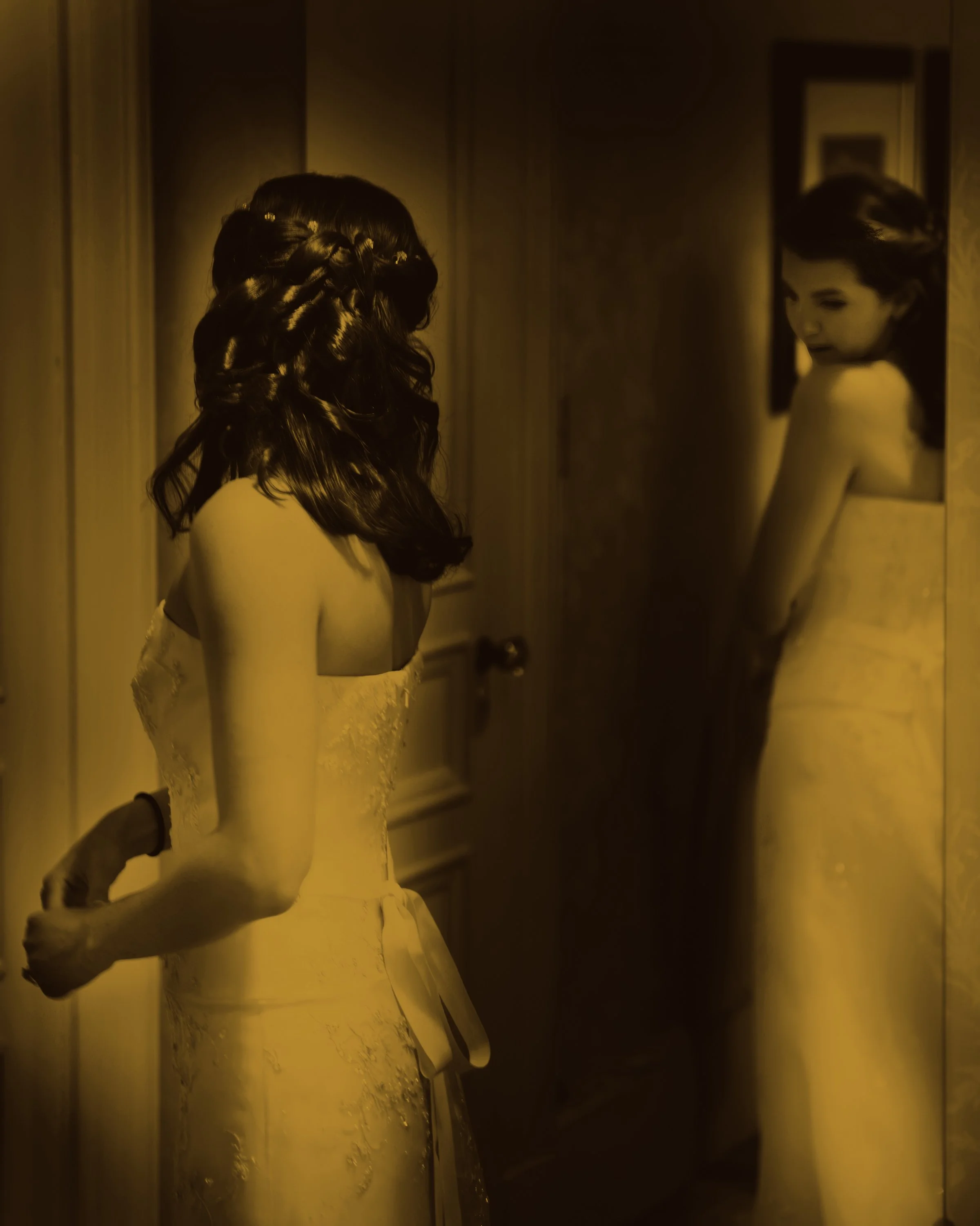 The bride looks in the mirror at Tappan Hill Mansion