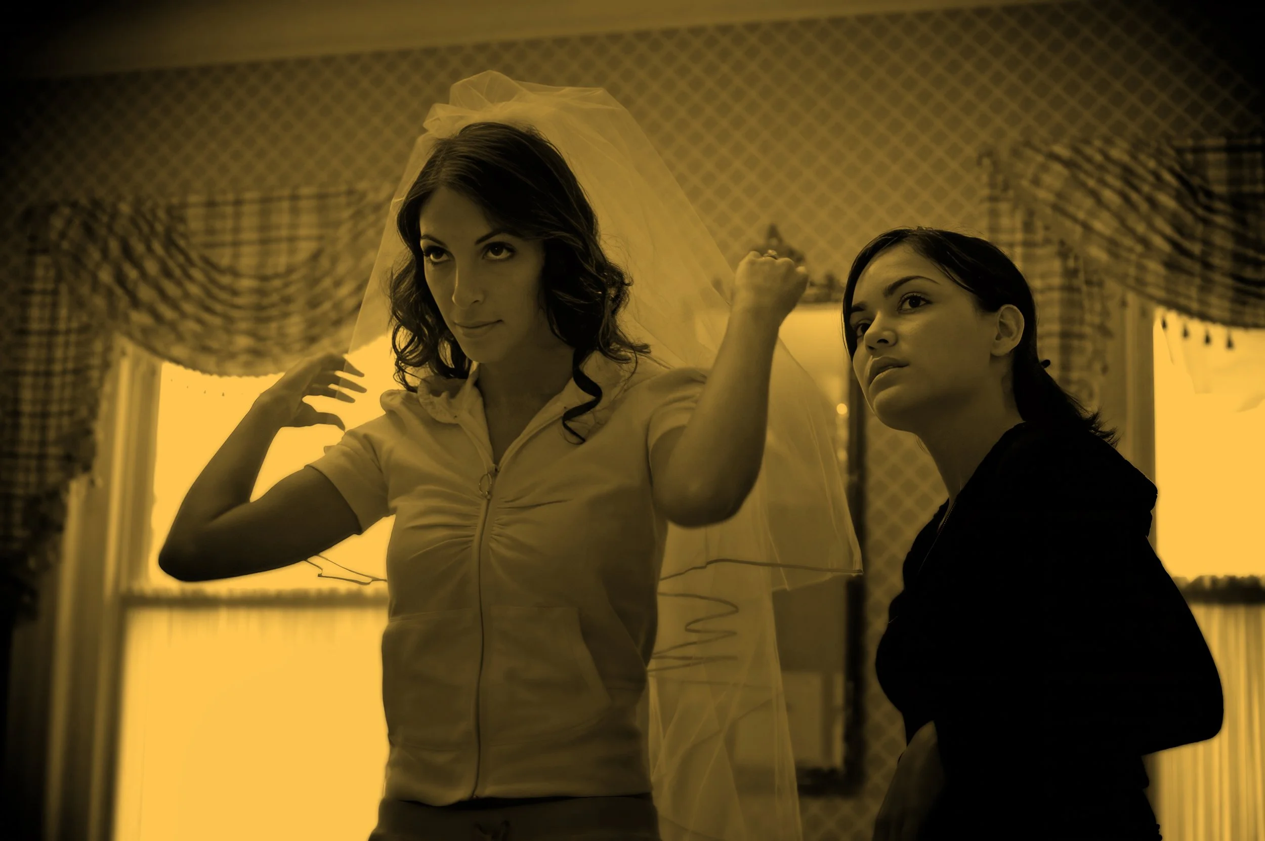 Bride adjusts her veil in the bridal suite, captured in soft natural light.