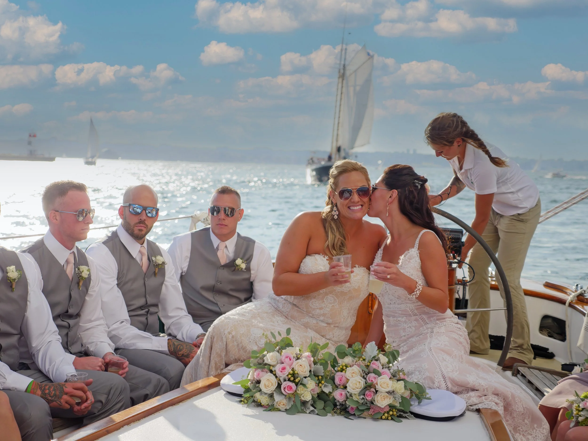 Two brides share a romantic moment on a 100-foot schooner under sail in Narragansett Bay near Newport.