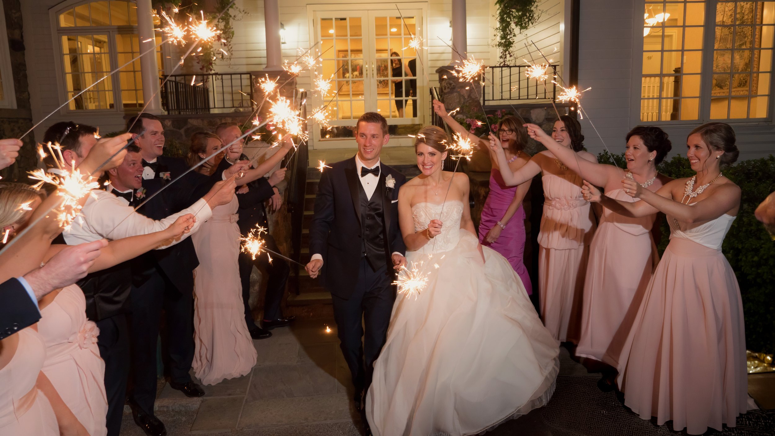 Bride and groom exit Salem Golf Club as friends and family line up with sparklers.