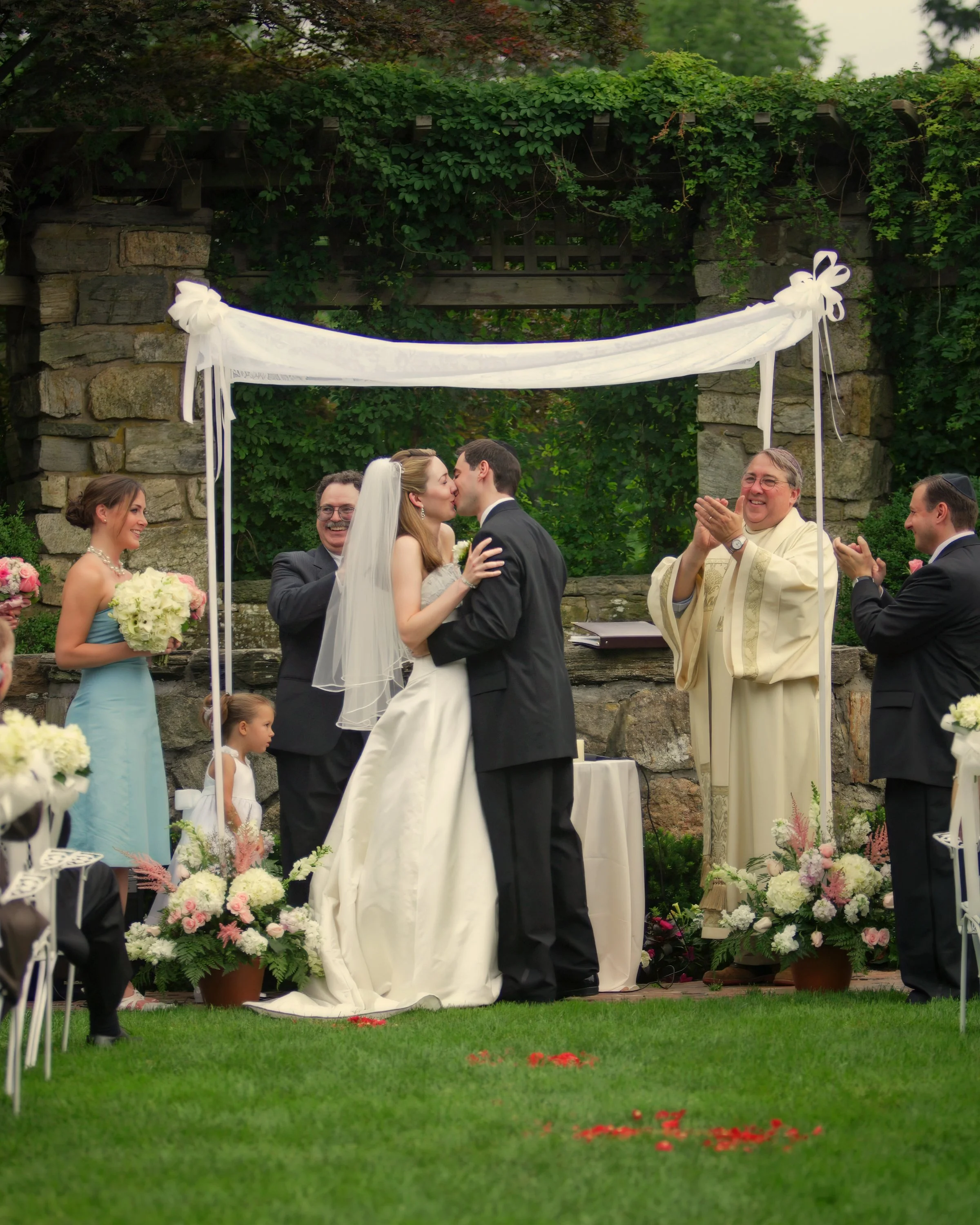 Bride and groom kiss beneath the chuppah during a Jewish wedding ceremony at Le Chateau