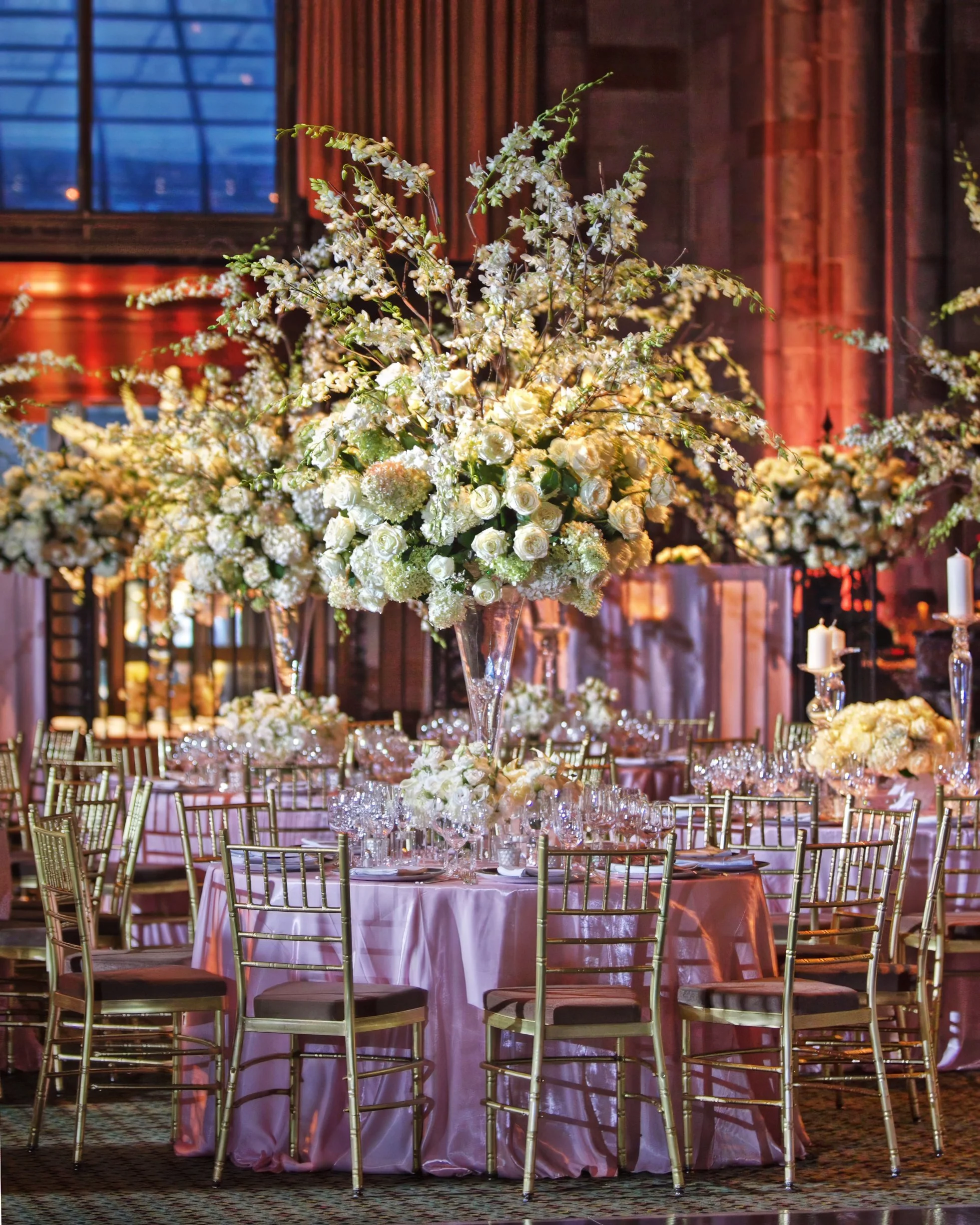 Tall floral centerpieces and elegant reception table settings at a wedding reception at Cipriani 42nd Street NYC.