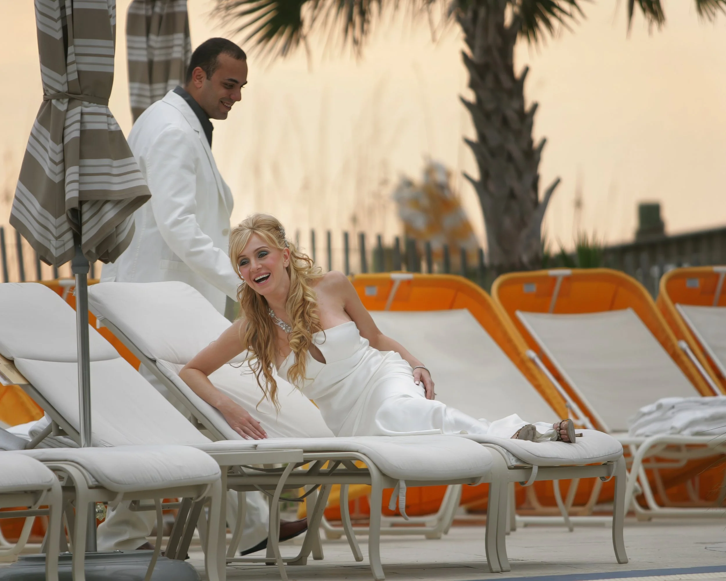 Bride and groom sharing a playful moment at the Ritz-Carlton Beach Club in Sarasota, Florida.