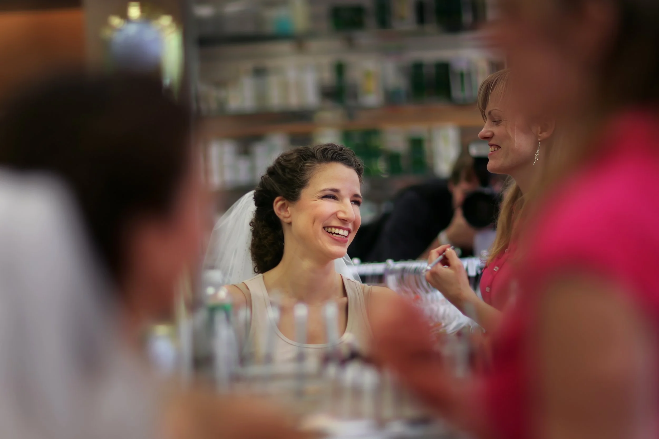 Bride’s reflection in the mirror as a makeup artist applies finishing touches at the Spa at Norwich Inn.