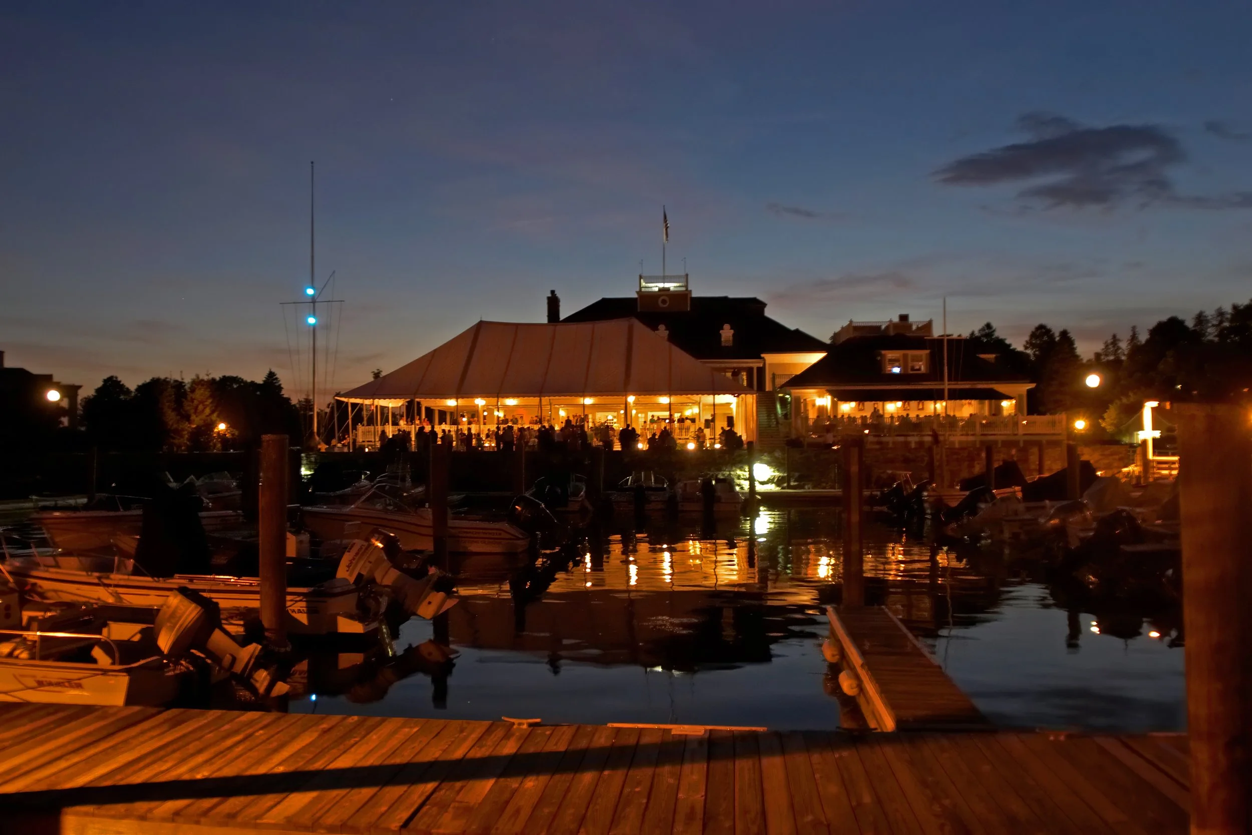 Belle Haven Yacht Club illuminated at night as seen from the docks.