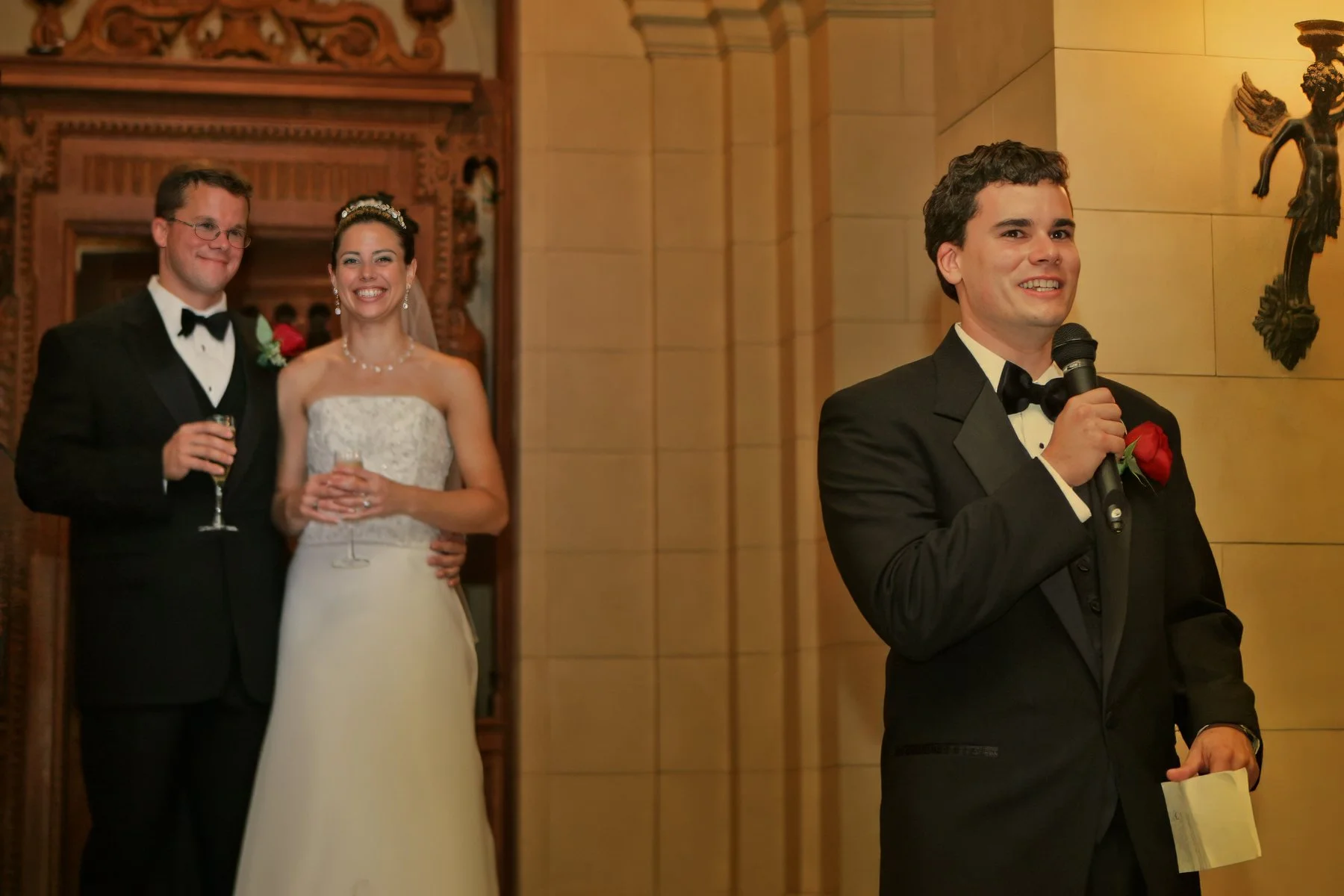 Best man delivering a heartfelt wedding toast while bride and groom listen during the reception.