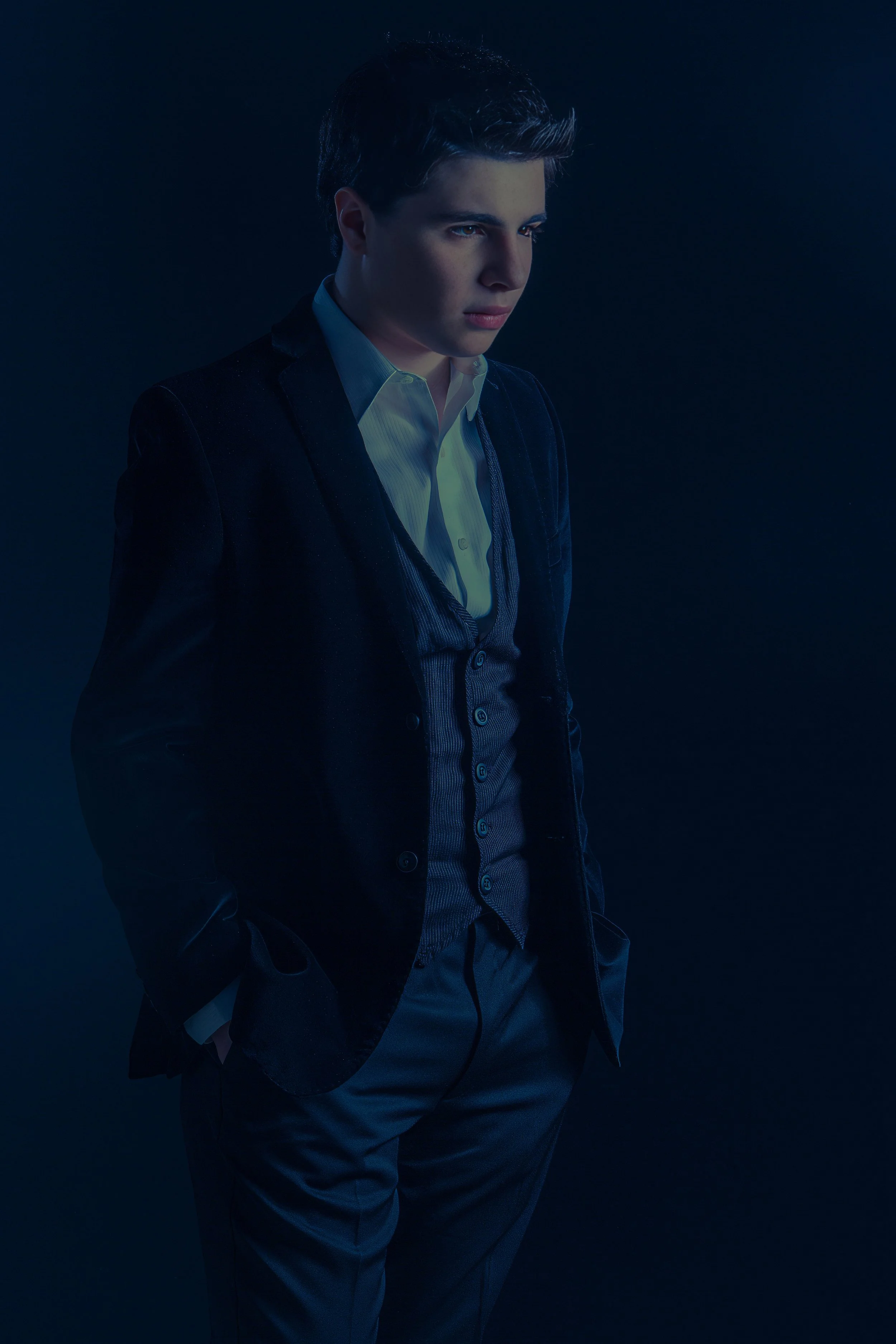 Teenage boy in luxury fashion photoshoot with dark twilight cinematic lighting