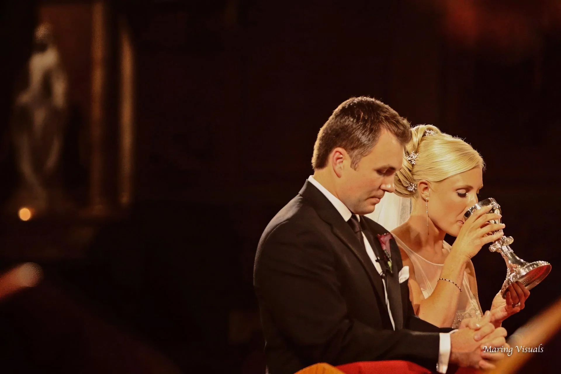 The bride and groom receive communion during the wedding ceremony in NYC