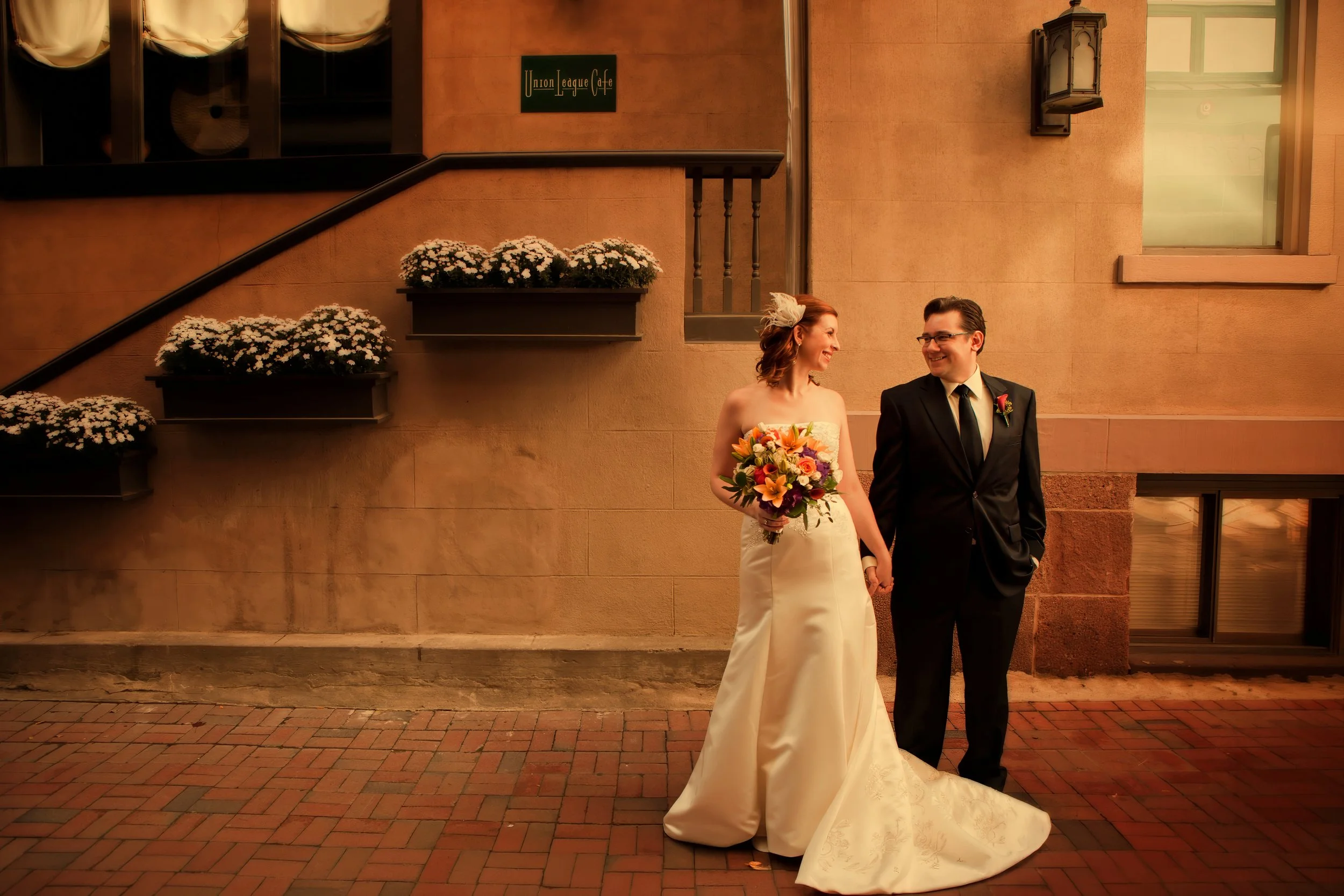 Bride and groom pose for a portrait outside the main entrance of Union League Cafe in New Haven, CT.