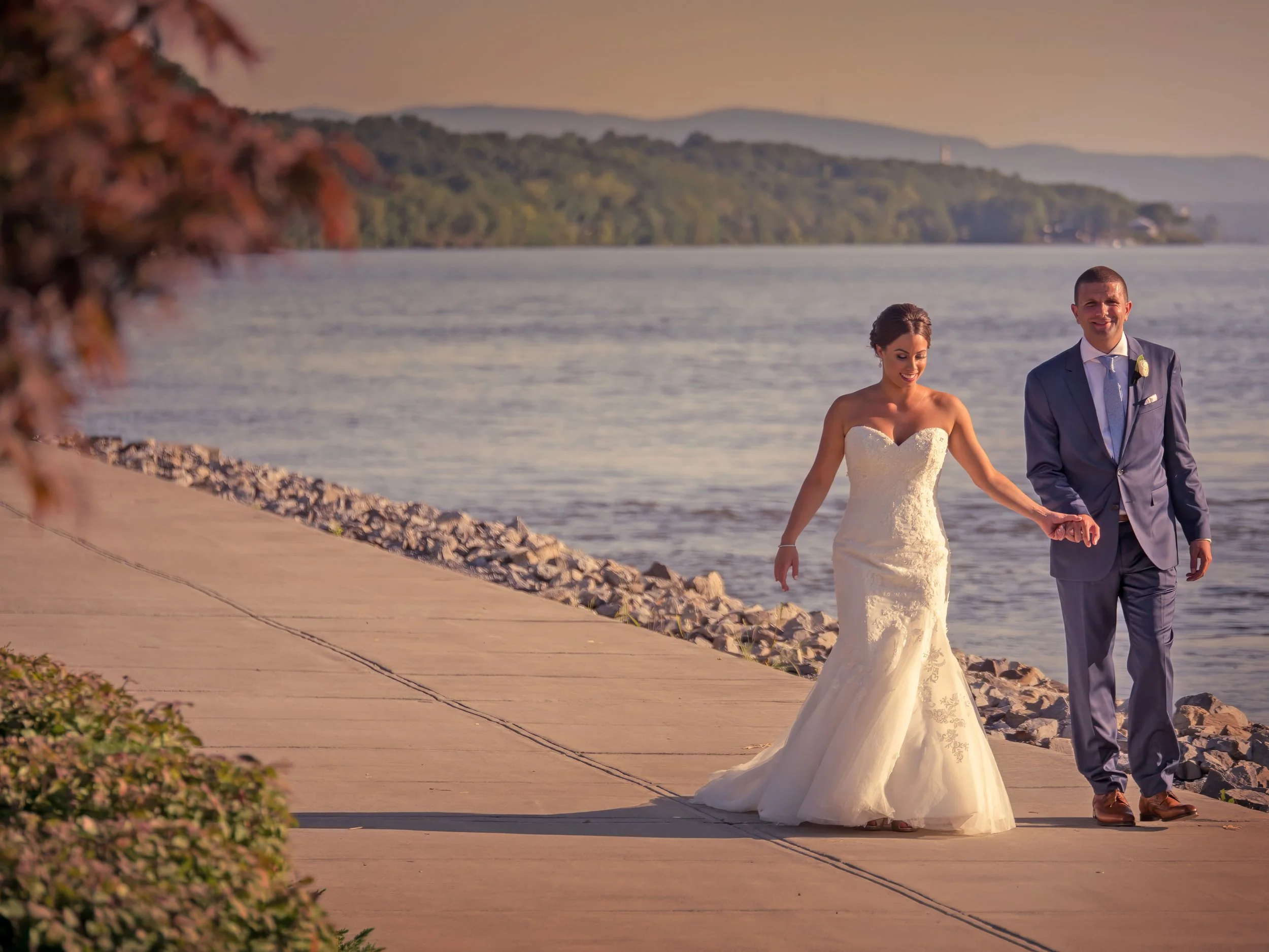 Bride and groom walk along the Hudson River at The Grandview.