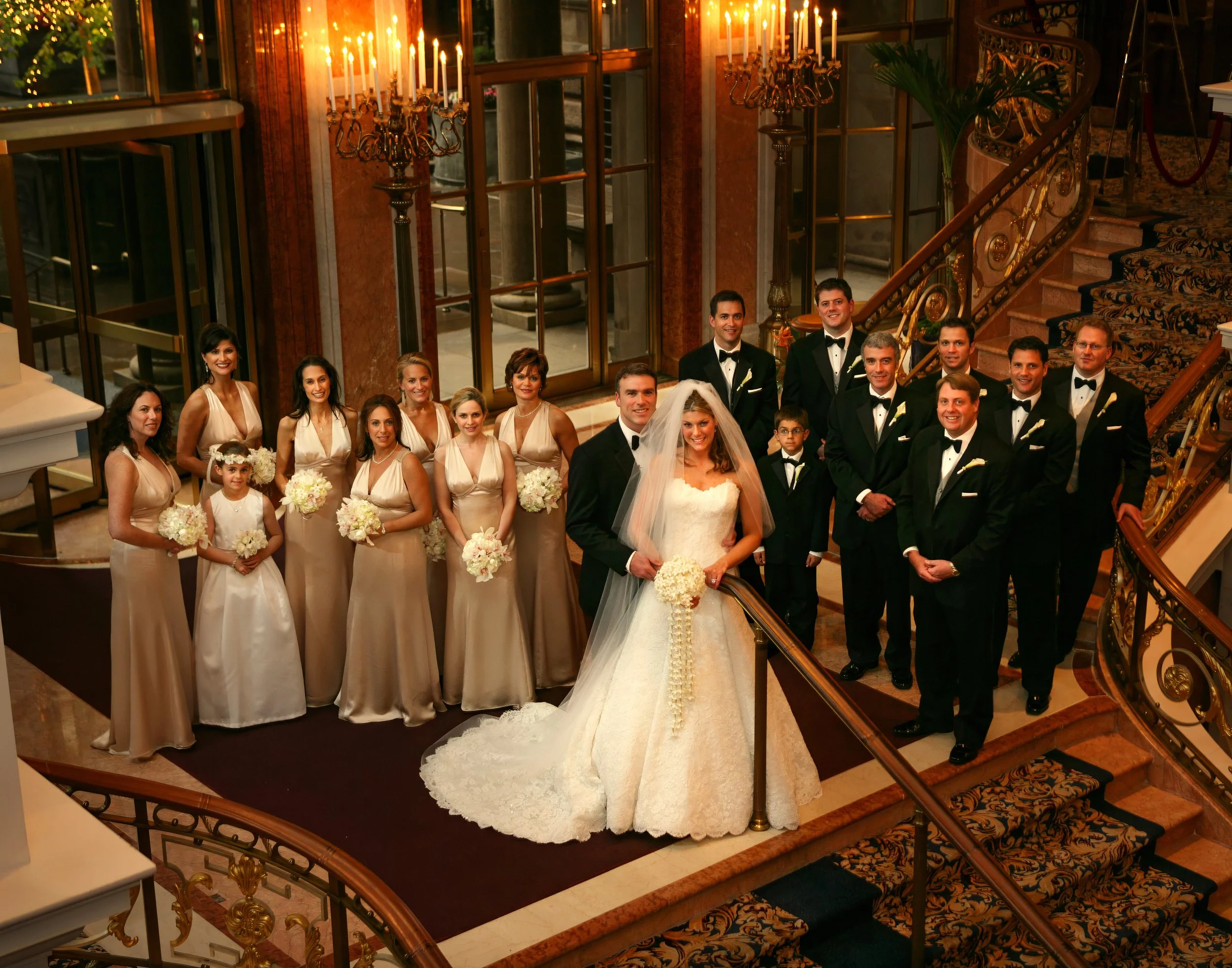 Sweeping wedding party portrait on the grand staircase of the New York Palace Hotel.