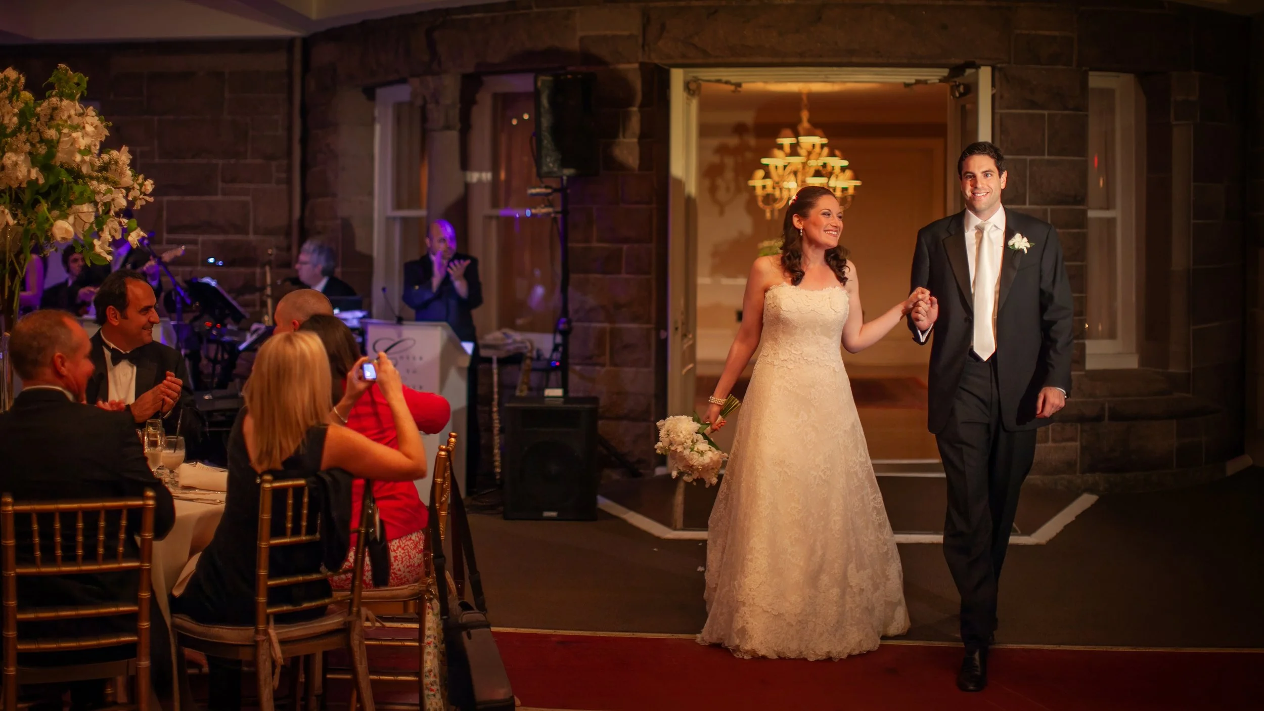 Bride and groom make a grand entrance into their wedding reception at Ocean Cliff.