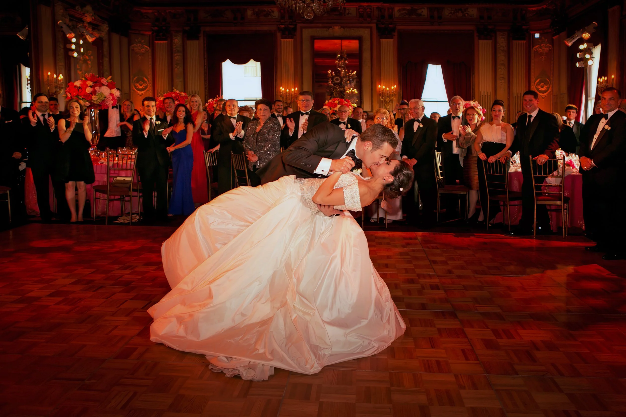 The groom dips the bride at the end of their first dance at their wedding reception in the ballroom of the Metropolitan Club NYC