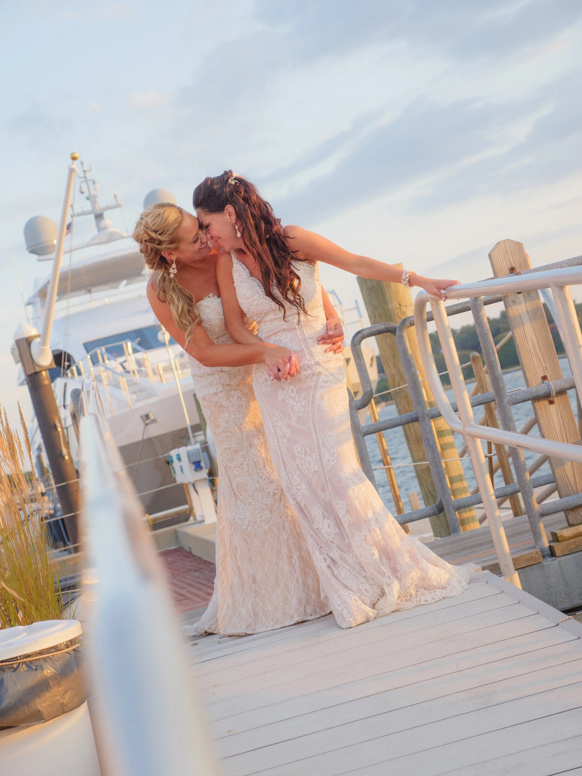 Two brides share a tender moment on the docks at the Newport Yachting Center.