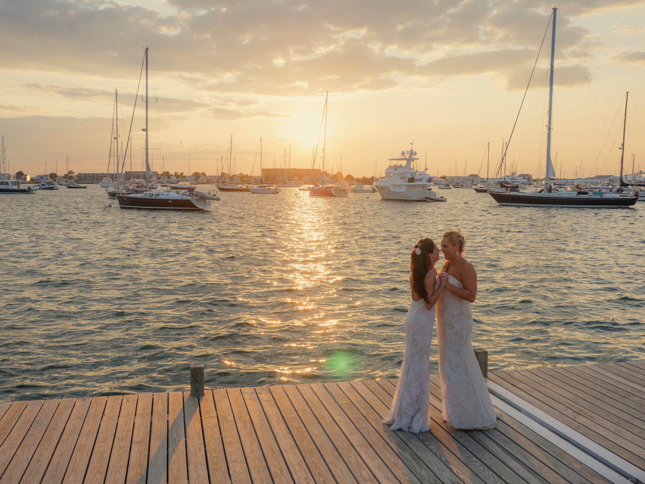 Newlyweds dance in the warm sunset light on the docks at The Bohlin, overlooking Newport Harbor.