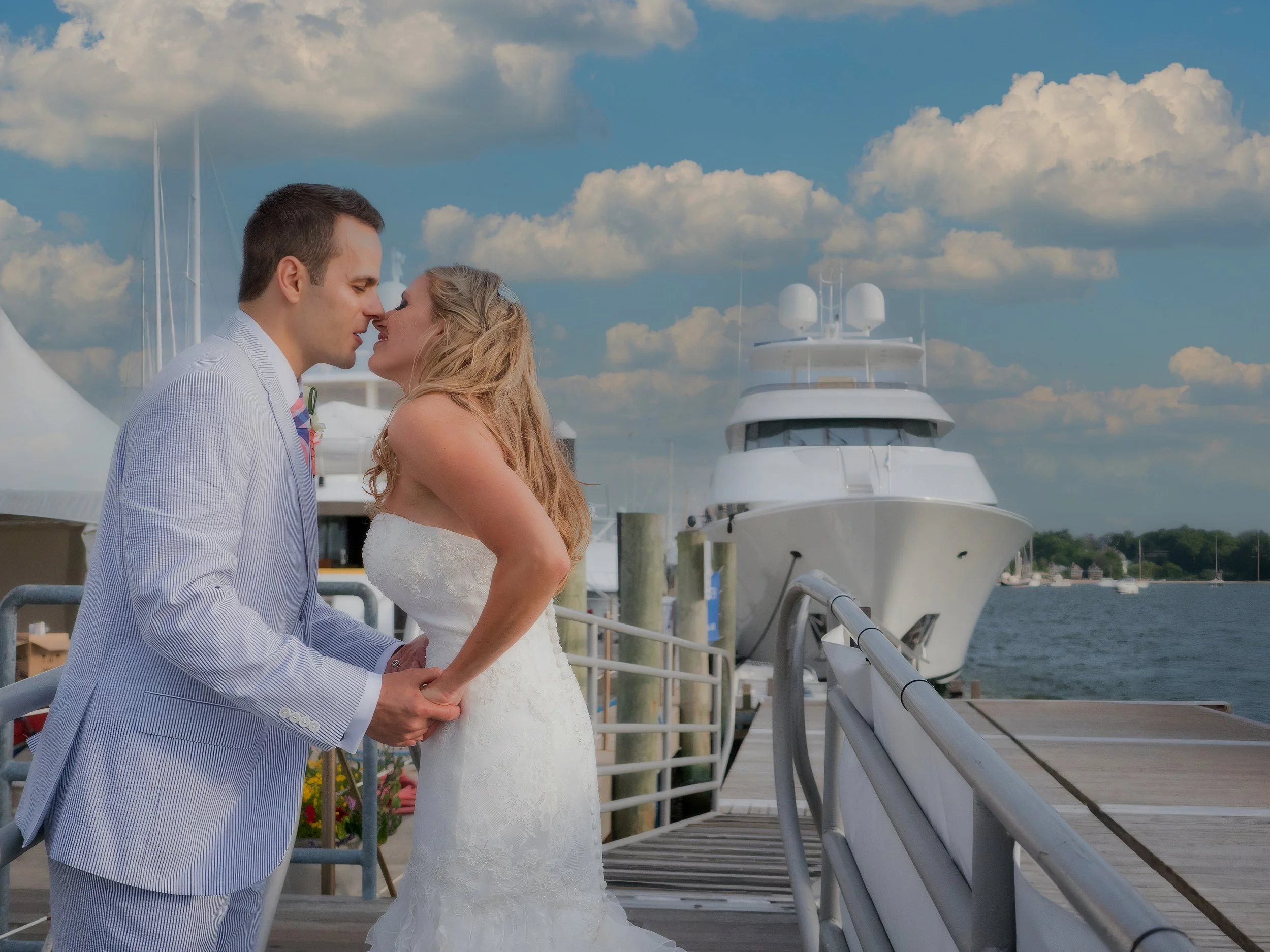 Bride and groom lean in for a kiss on the docks at the Newport Yachting Center during their harbor wedding.